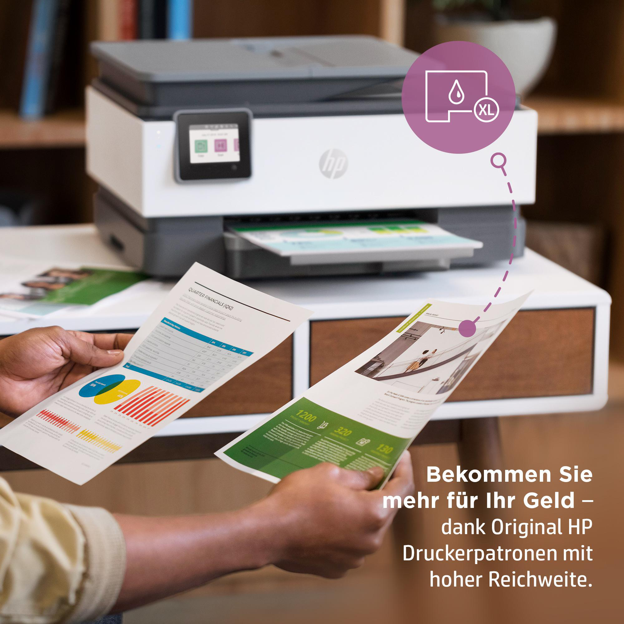 Eine Person hält bedruckte Papiere mit Diagrammen, blickt im Hintergrund auf einen Drucker.