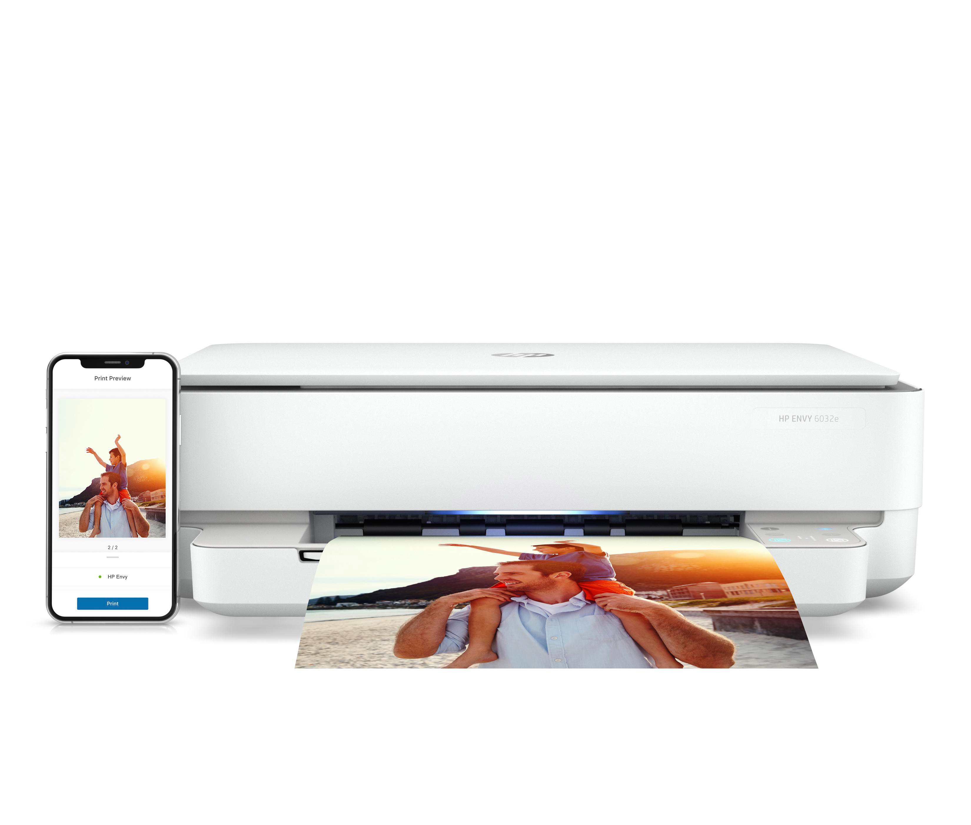 Ein weißer HP Envy Drucker mit einem gedruckten Foto und einem Telefon, das ein Foto zeigt.