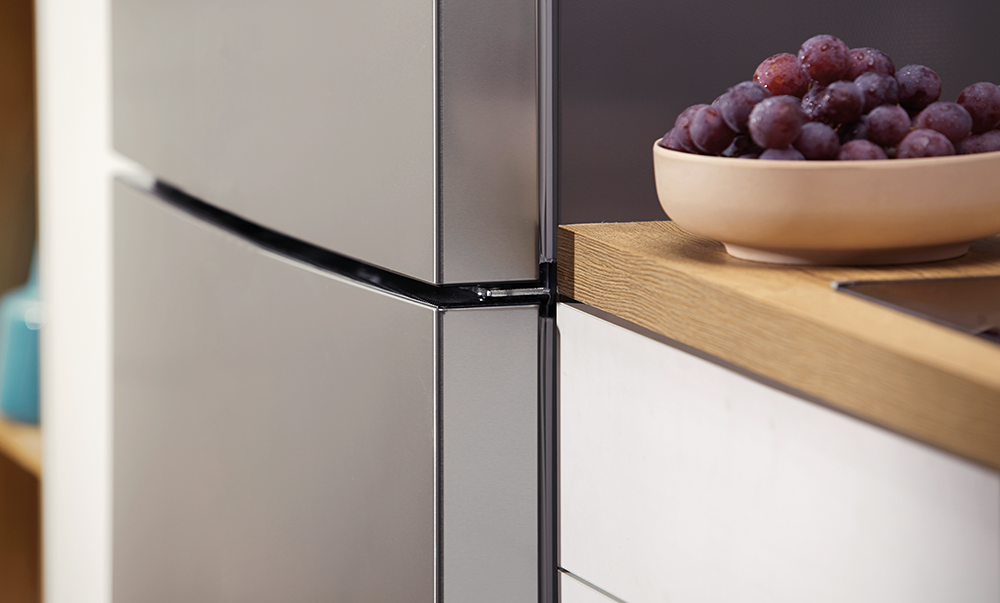 Zbliżenie szafki kuchennej z miską winogron na drewnianym blacie.