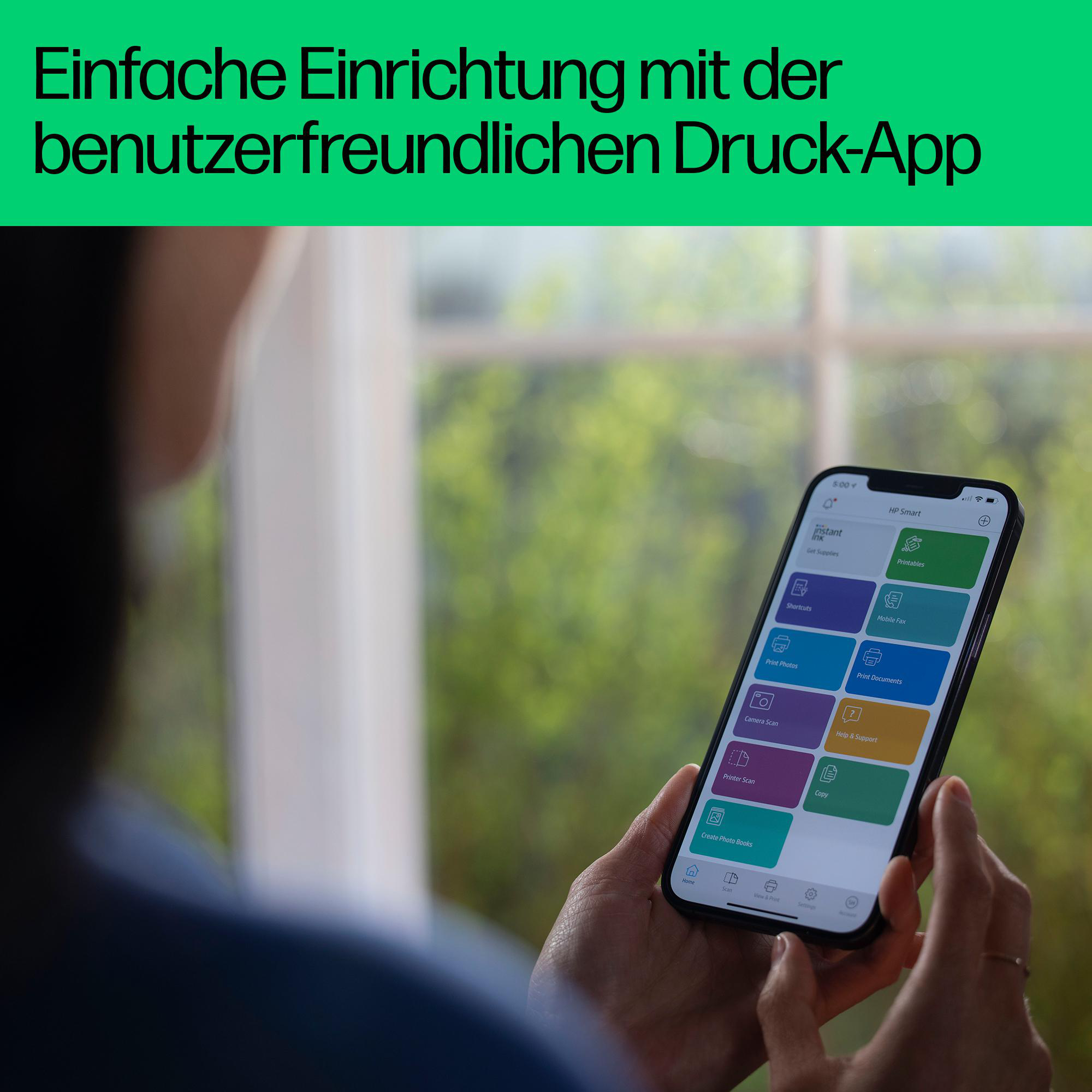 Die Hand einer Person hält ein Telefon, das eine App mit verschiedenen Druckoptionen anzeigt.