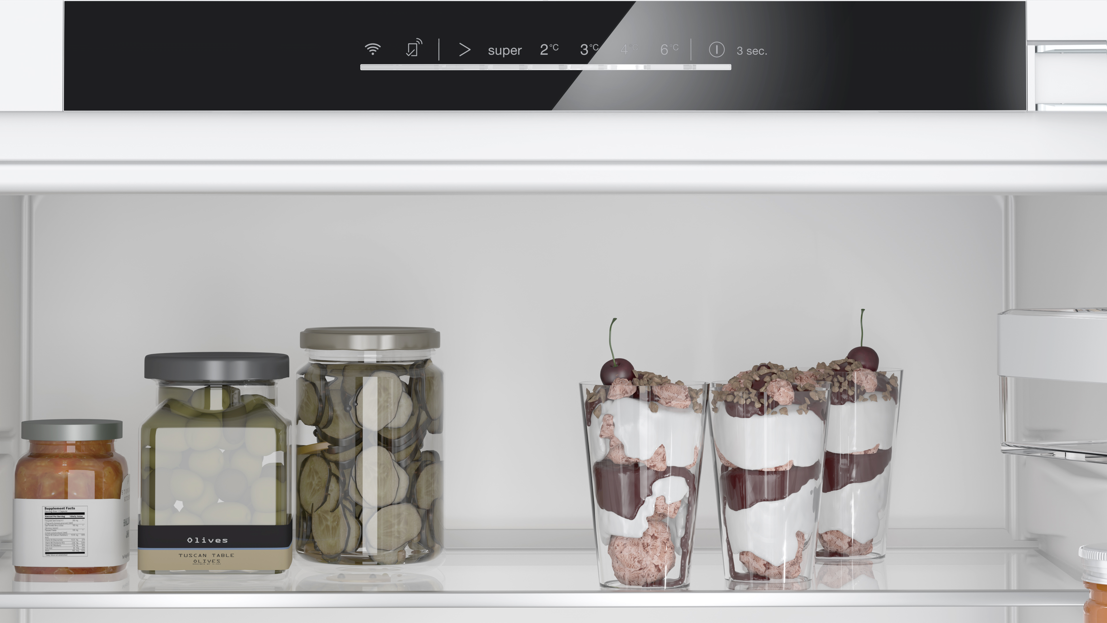 Kühlschrank-Innenraum: Gläser mit Essiggurken und Desserts in Regalen.