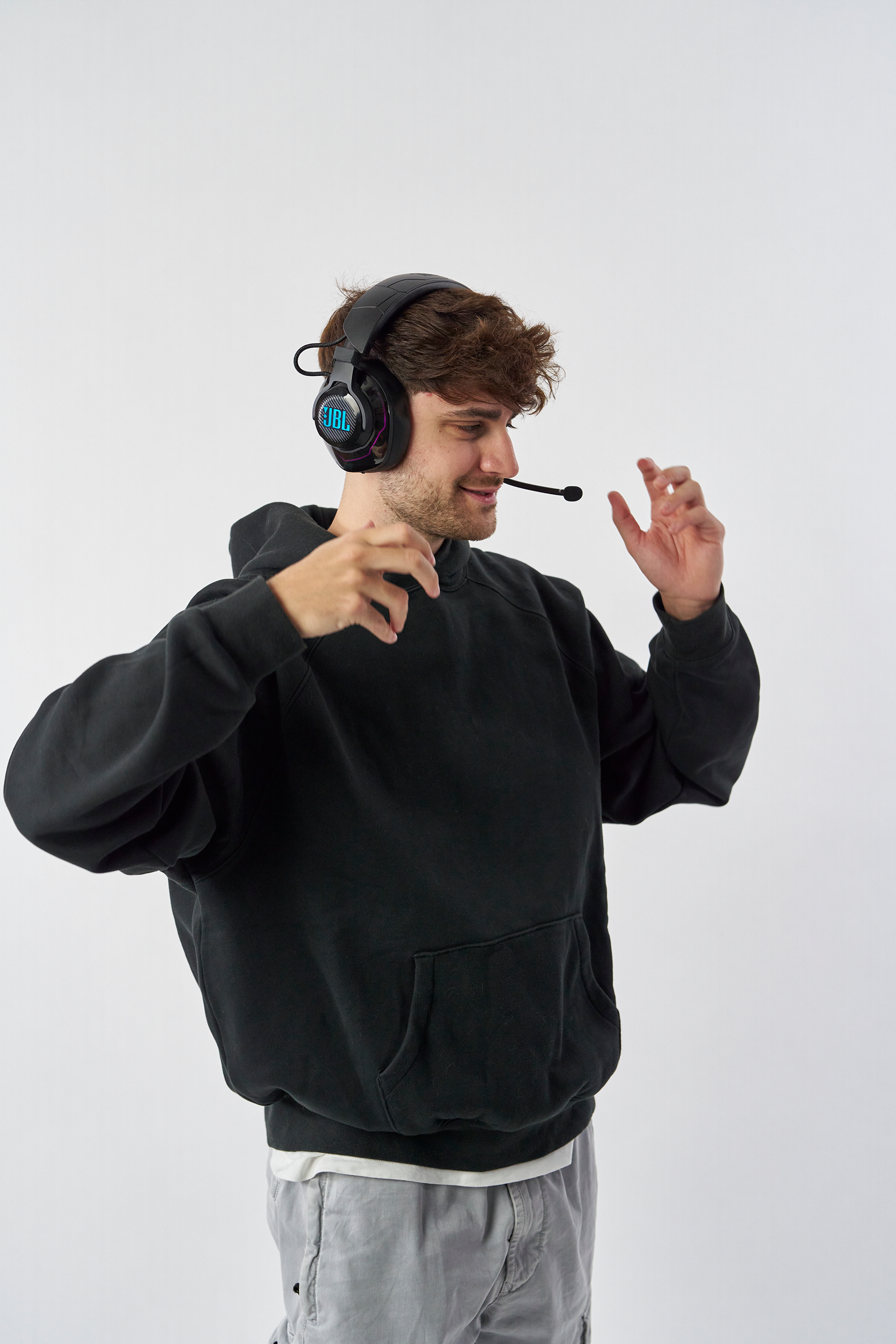 Jeune homme portant un casque avec micro, souriant et gesticulant.