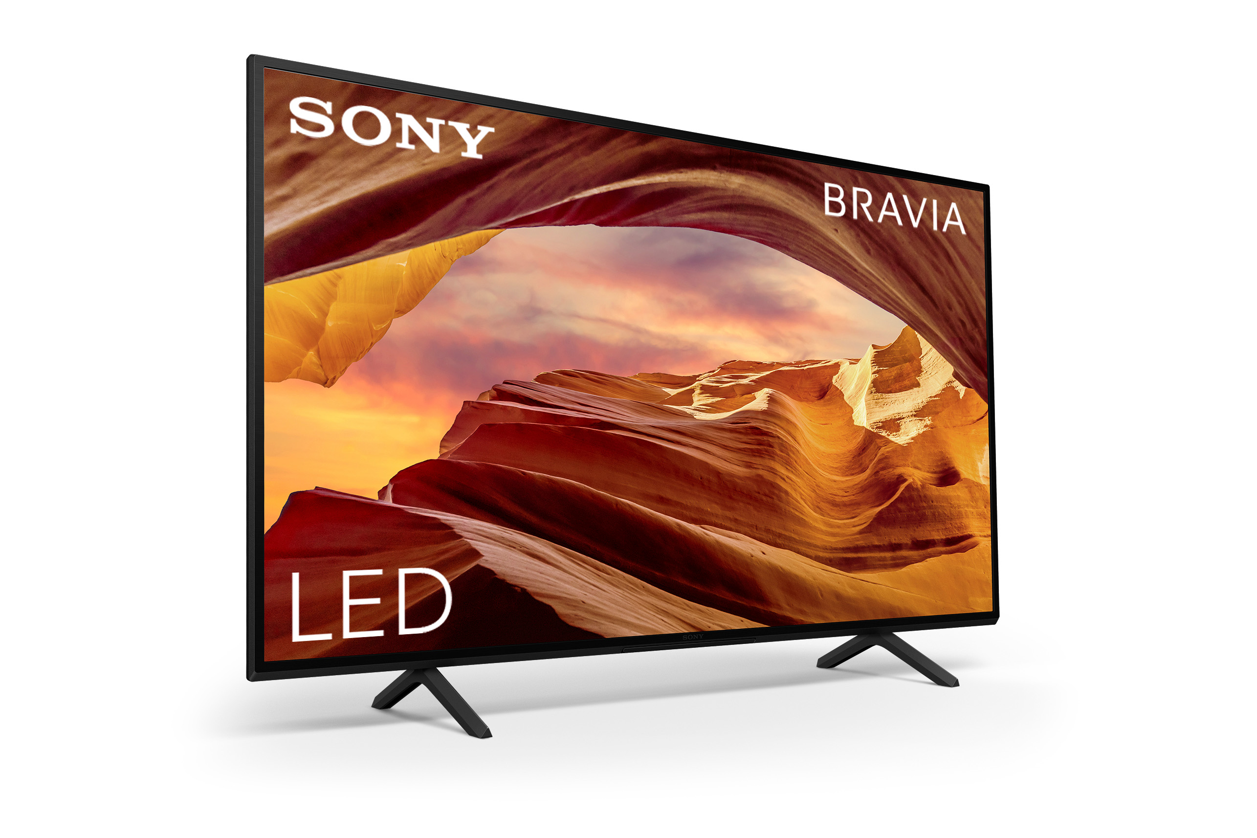 Un televisor de pantalla plana sobre un fondo blanco. La pantalla muestra un paisaje de puesta de sol.