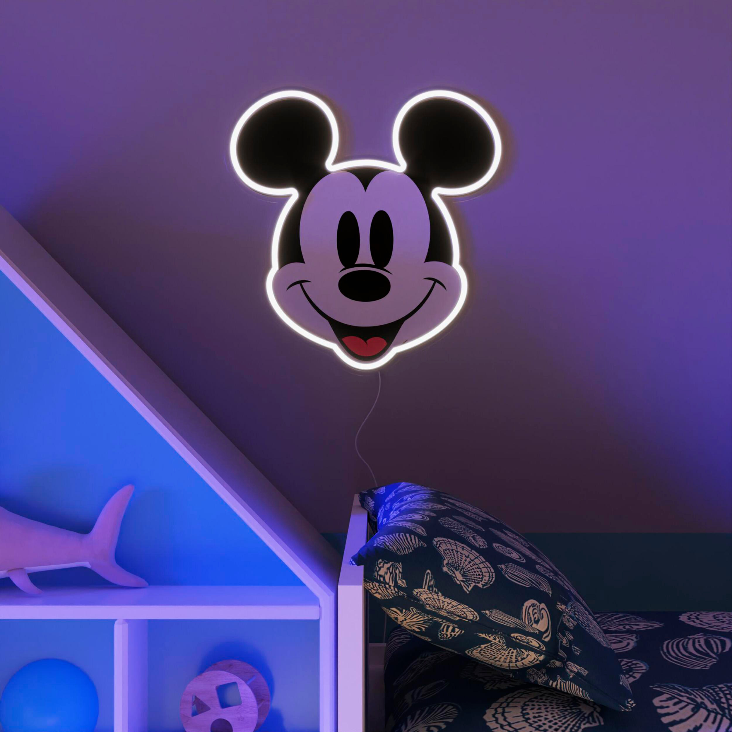 Mickey Mouse Neonlicht. Es befindet sich an einer Wand über einem Bett. Darunter befinden sich ein Regal und ein Kissen.