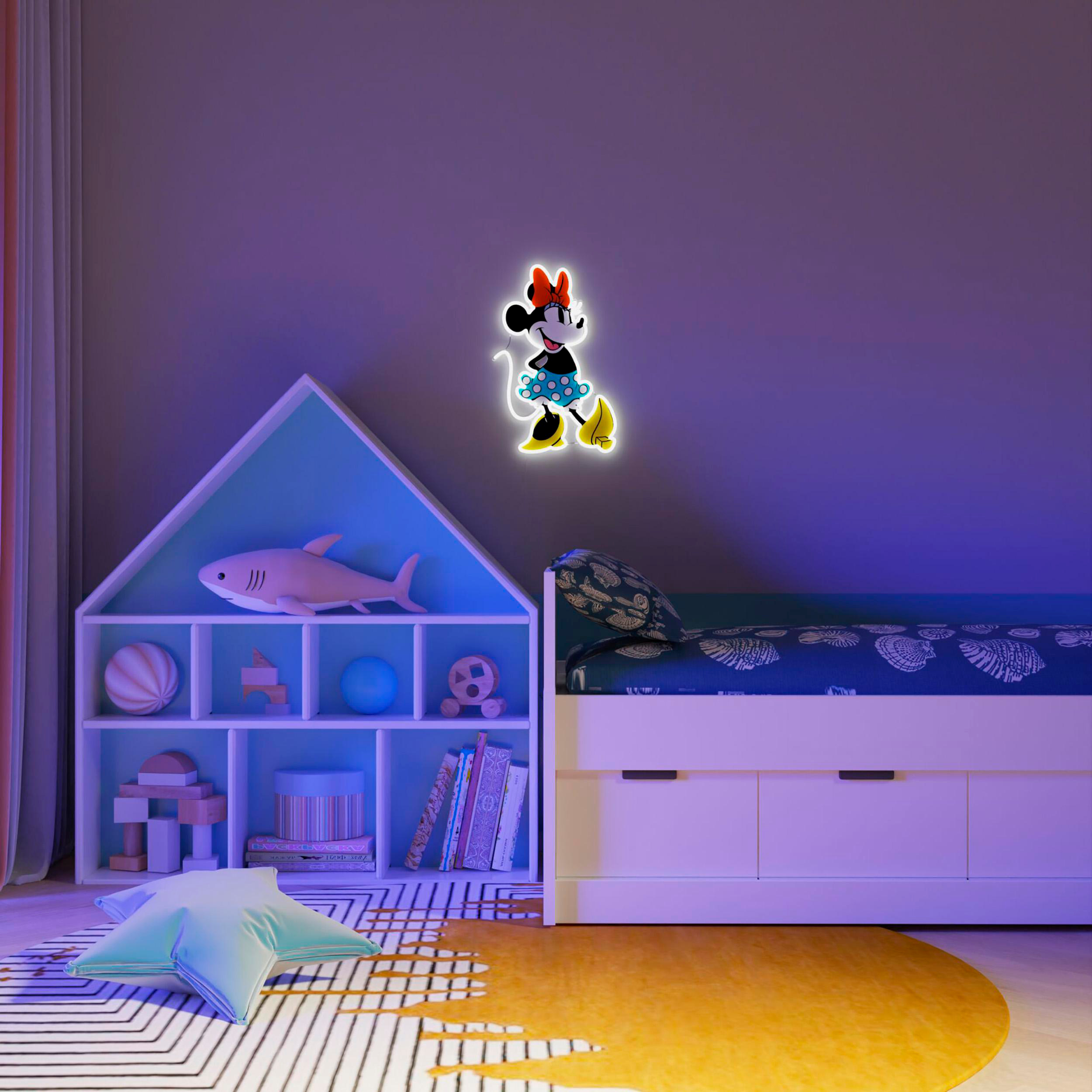 Ein Minnie-Maus-Licht an einer lila Wand, über einem Bett. Ein Bücherregal und ein sternförmiges Kissen sind sichtbar.