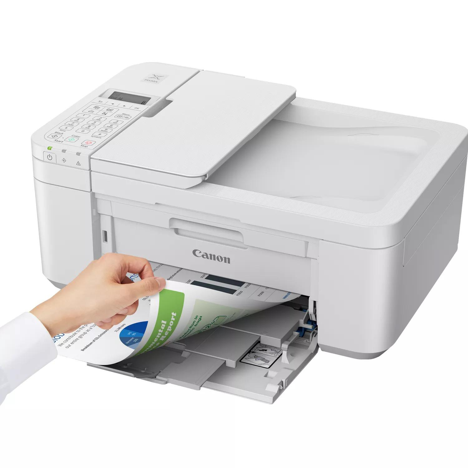 Eine Hand legt ein Papier in einen weißen Canon-Drucker mit einem Dokument ein.