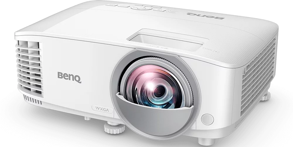 Fehér BenQ projektor. Elölnézet lencsével és szellőzőráccsal. Fekete háttér.