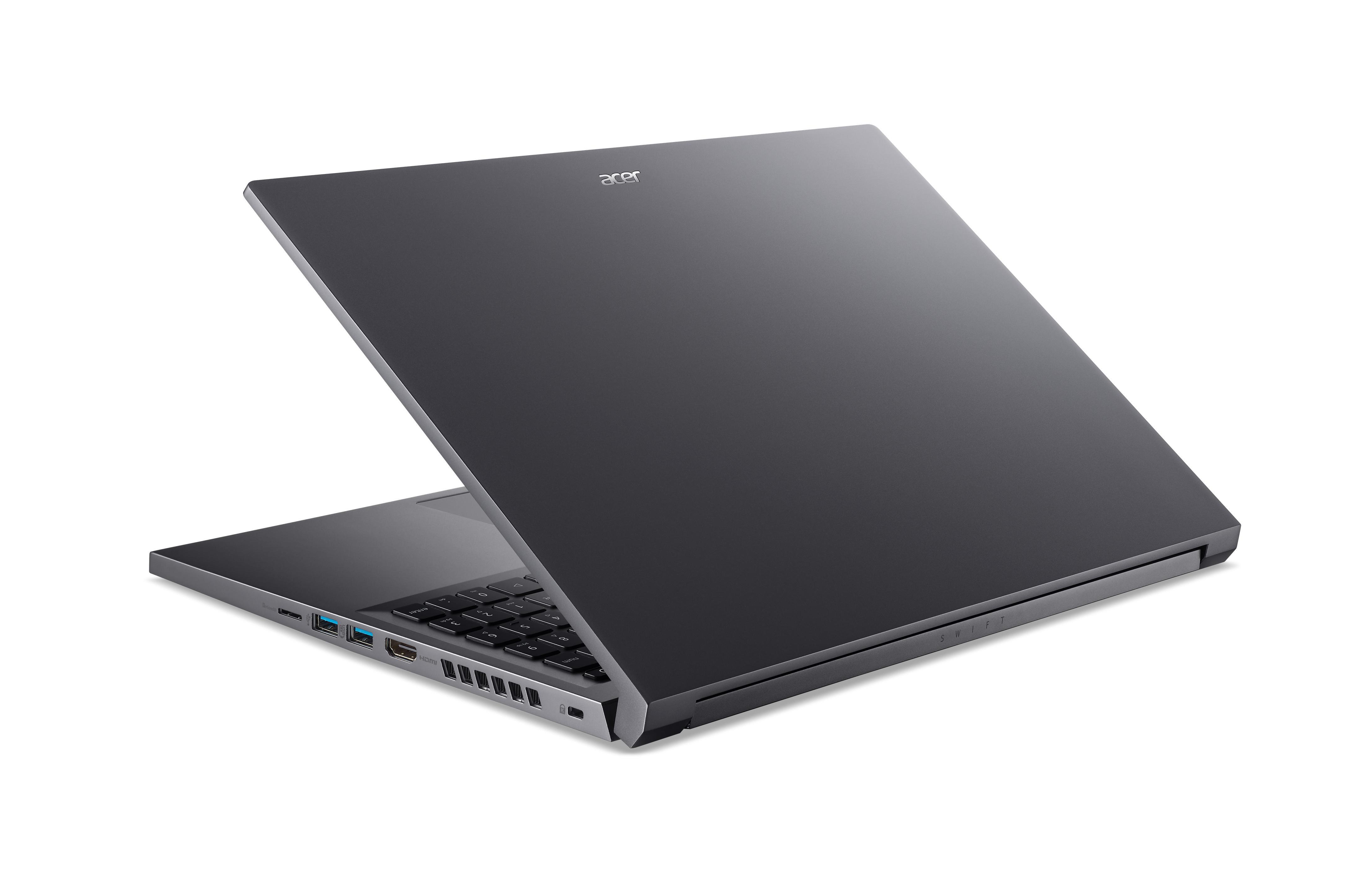 Ein grauer Laptop, geöffnet, wird von hinten gezeigt, wobei Tastatur und Anschlüsse sichtbar sind, isoliert auf Weiß.
