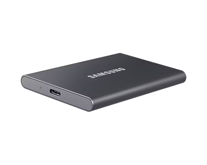 Koyu gri Samsung harici sabit sürücü, USB-C bağlantı noktasıyla, siyah yüzeyde.