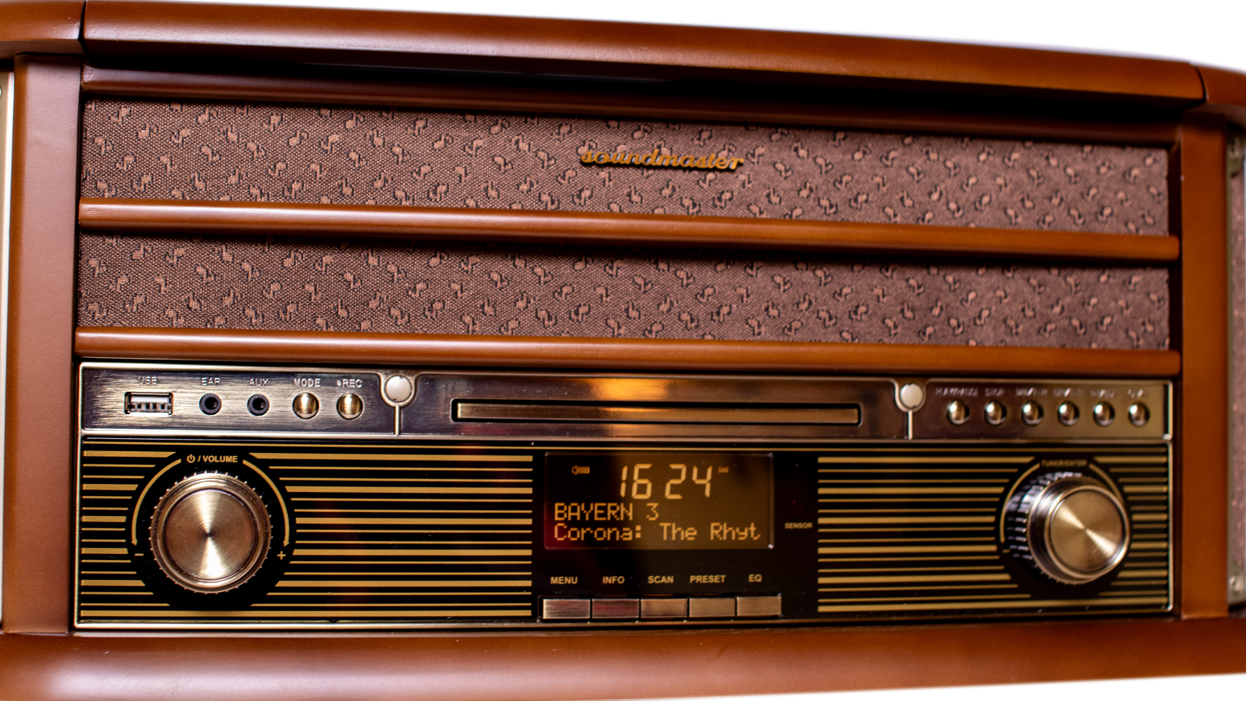 Une radio vintage marron avec affichage numérique, cadran et boutons, sur une surface en bois.