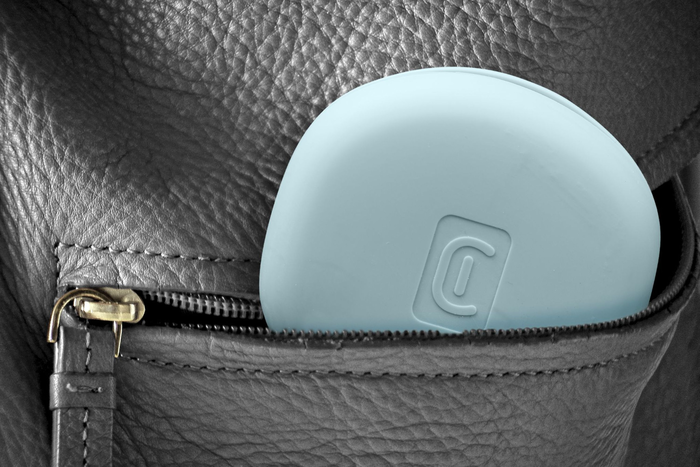 Ein hellblaues Objekt mit einem 'C'-Logo befindet sich teilweise in einer schwarzen Ledertasche, der Reißverschluss ist teilweise geöffnet.