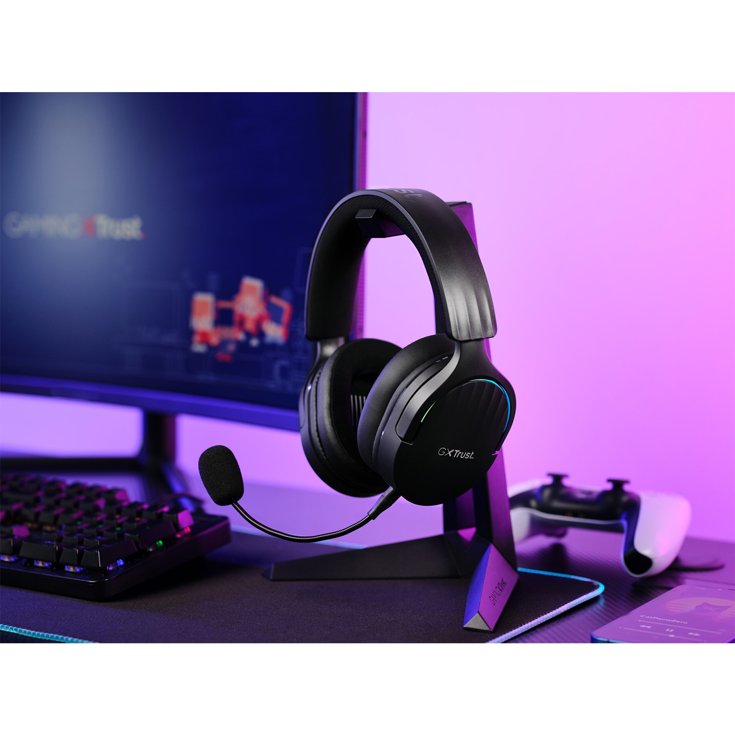 Cuffie nere su supporto, tastiera, monitor e gamepad.