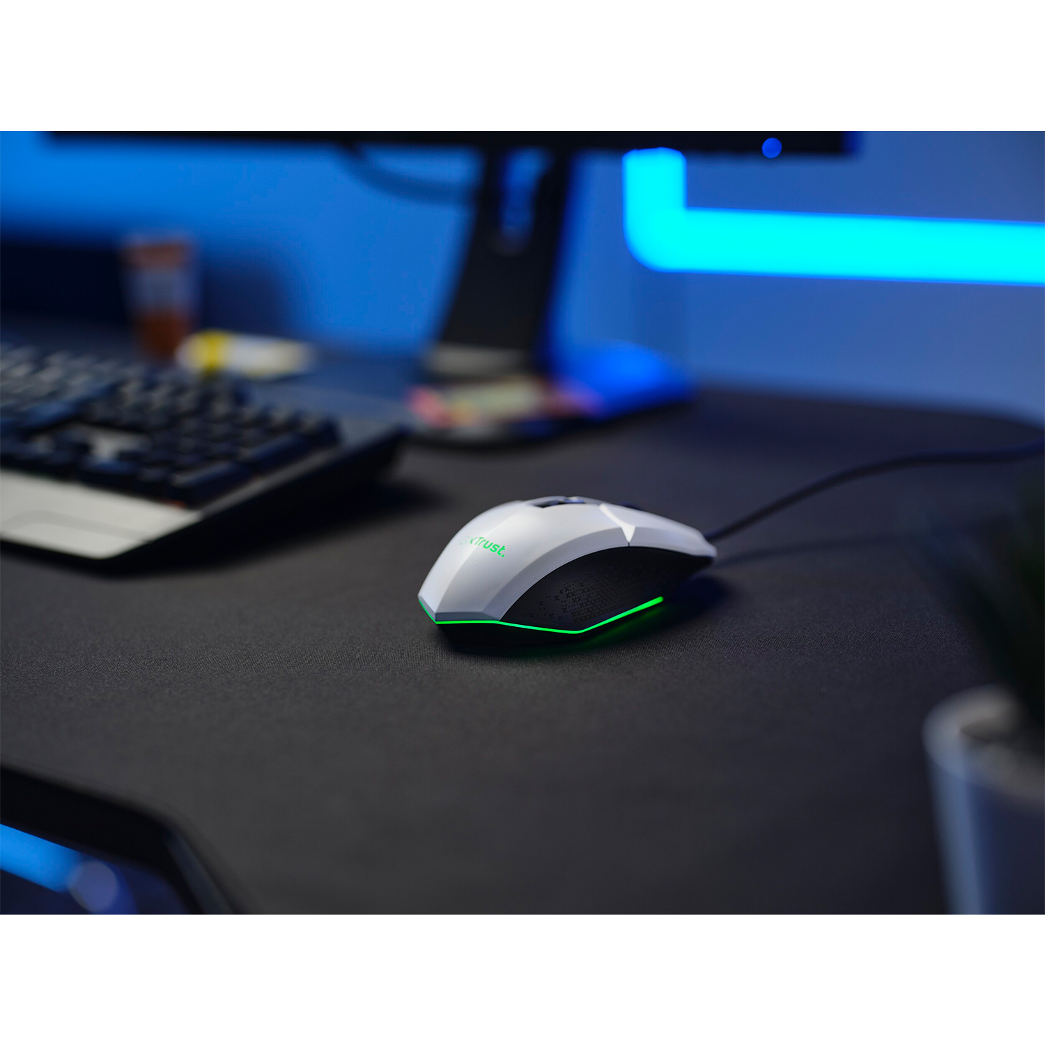 Mouse da gaming nero con accenti verdi su scrivania nera.