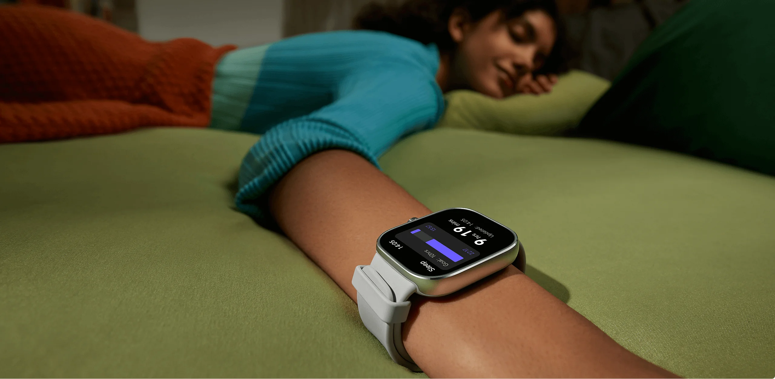 Persona con smartwatch. Mostra dati del sonno. Persona sdraiata su superficie verde.