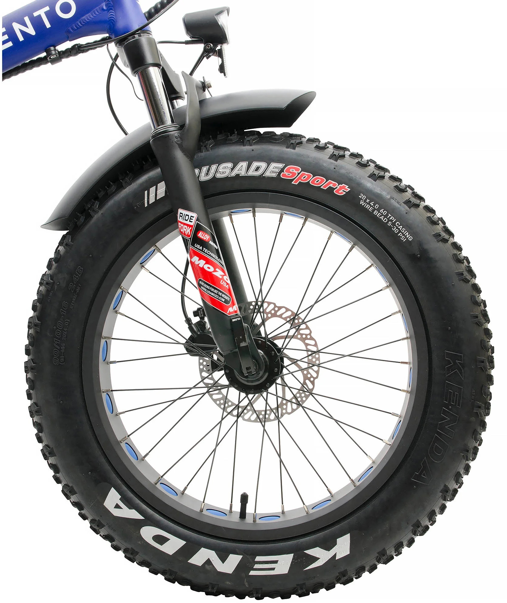 Zbliżenie koła roweru fat bike. Czarna opona z białymi literami, niebieskimi akcentami i hamulcem tarczowym.