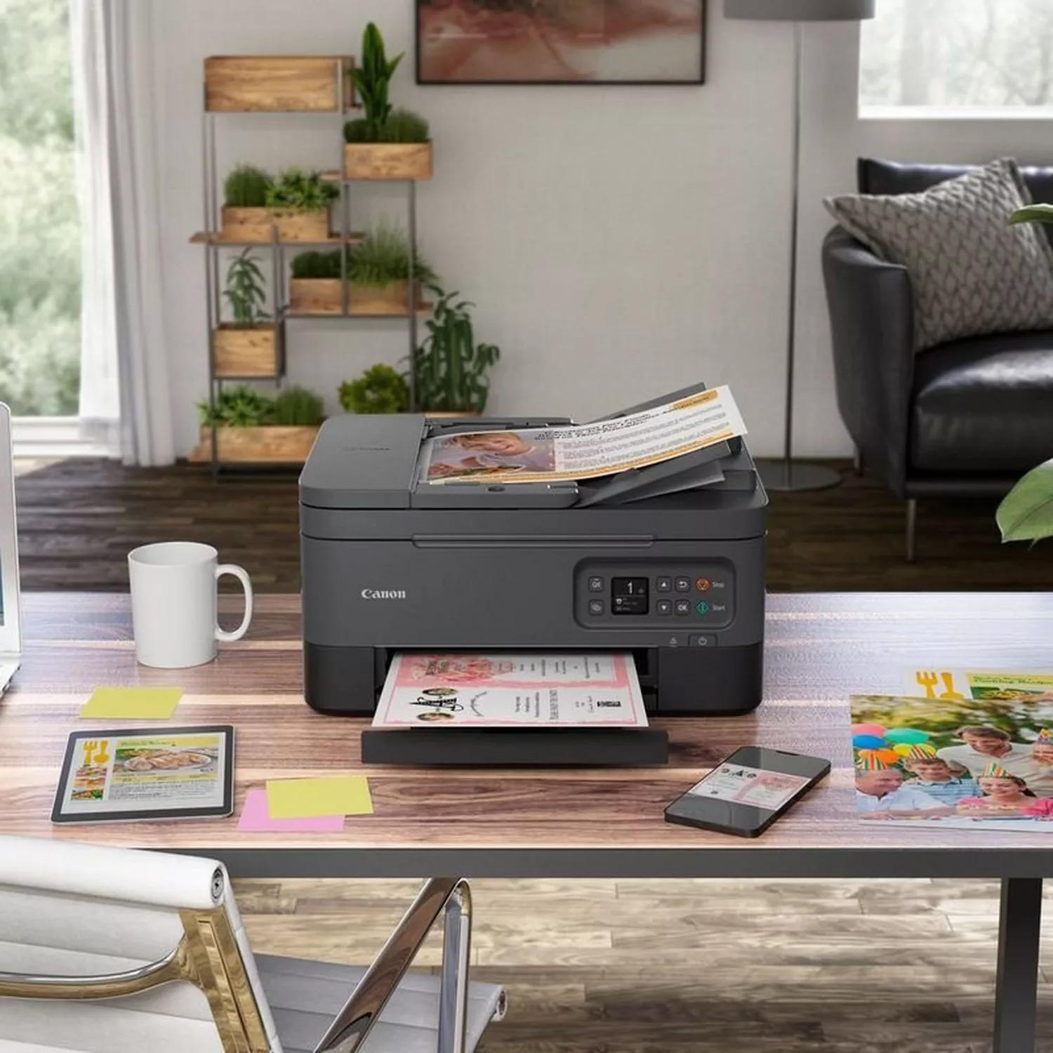 Canon-Drucker auf einem Schreibtisch mit Gegenständen: Tasse, Tablet und Telefon.