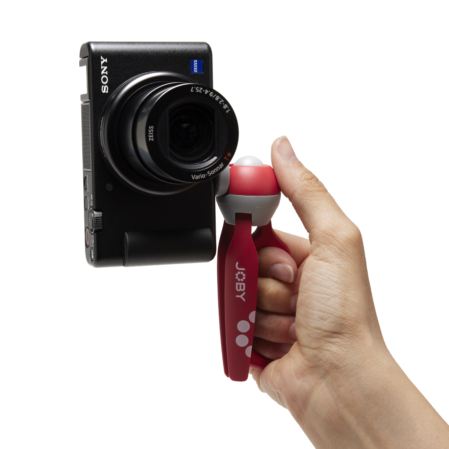 Hand met een camera op een statief, zwarte achtergrond.
