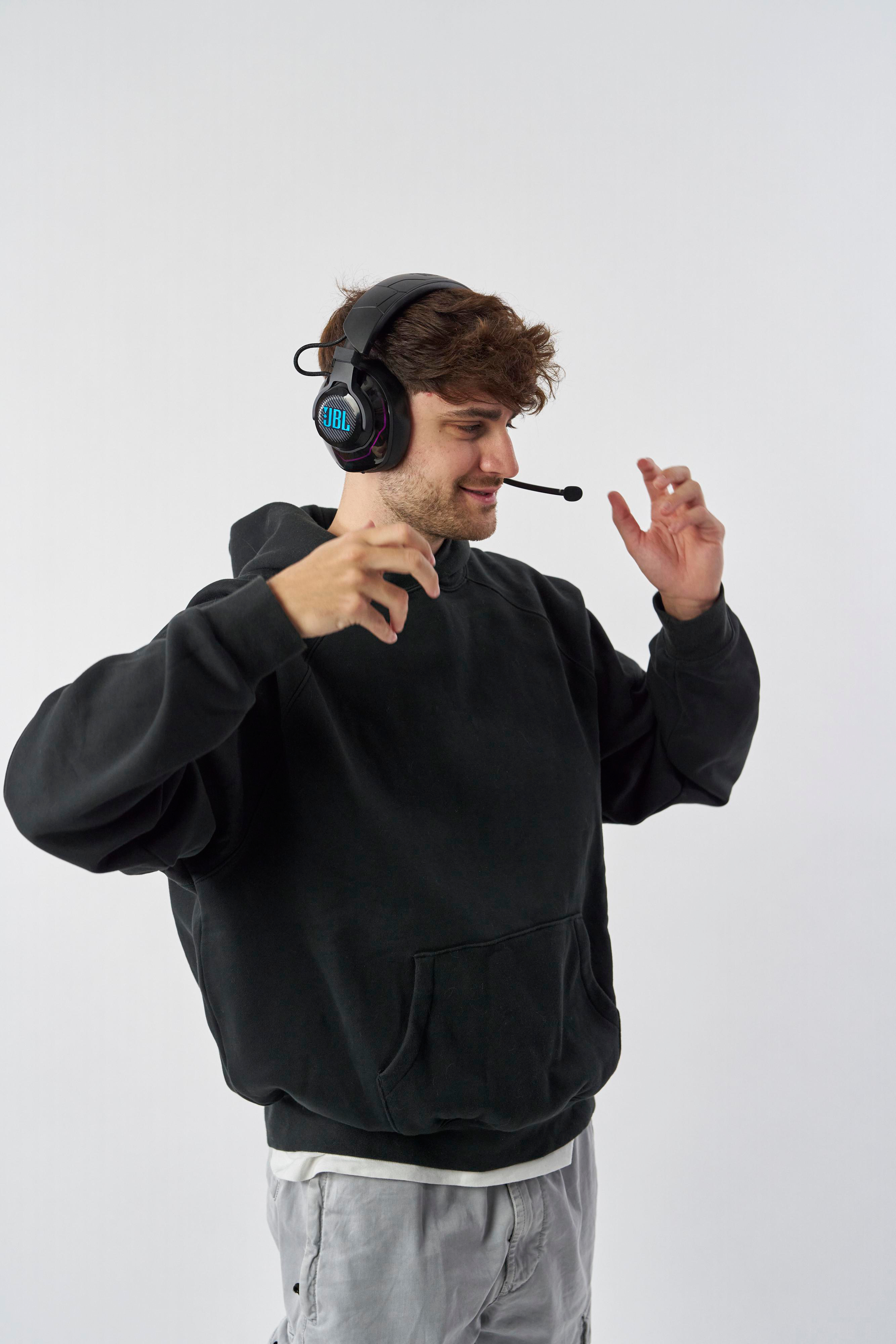 Ein Mann mit Headset, der das Mikrofon hält und lächelt.