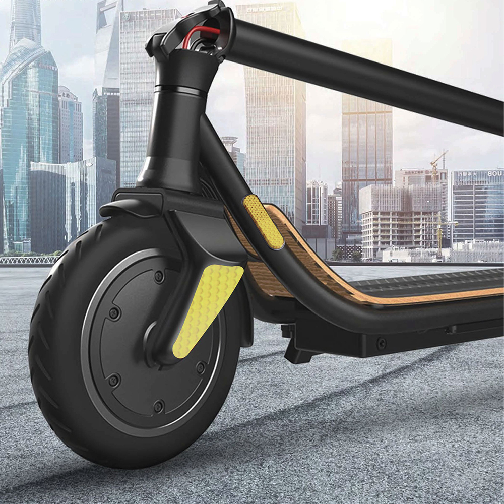 Zbliżenie przedniego koła hulajnogi elektrycznej, pokazujące czarną oponę i ramę hulajnogi.