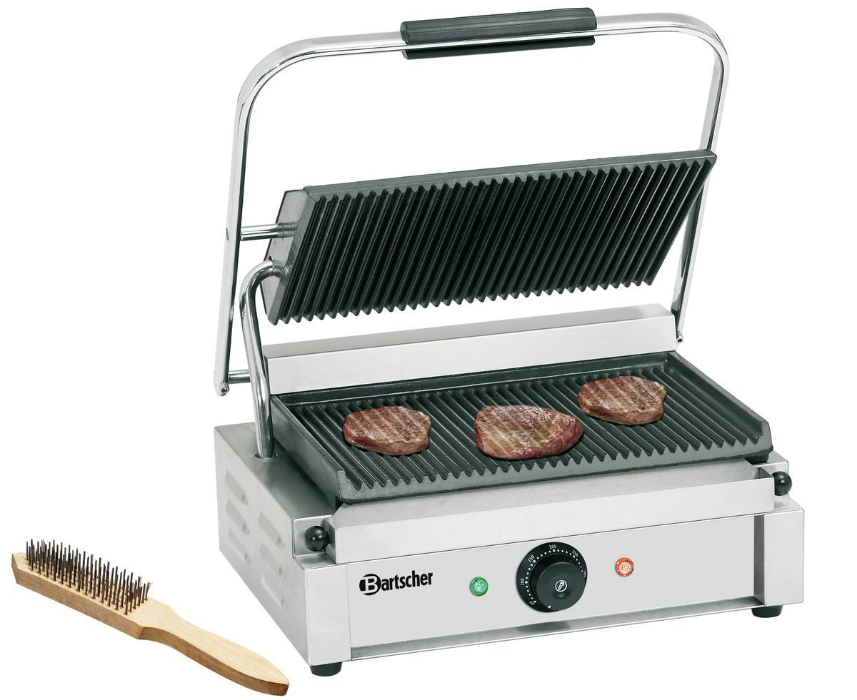 Ein kommerzieller Grill mit drei Steaks. Links liegt eine Bürste. Der Grill hat einen Griff und Temperaturregler.