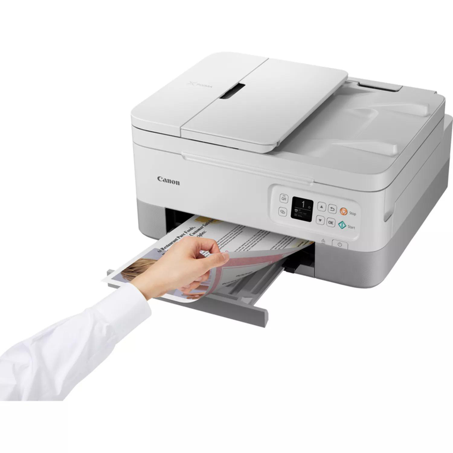 Eine Hand zieht ein gedrucktes Dokument aus einem Canon-Drucker. Der Drucker ist weiß und grau.