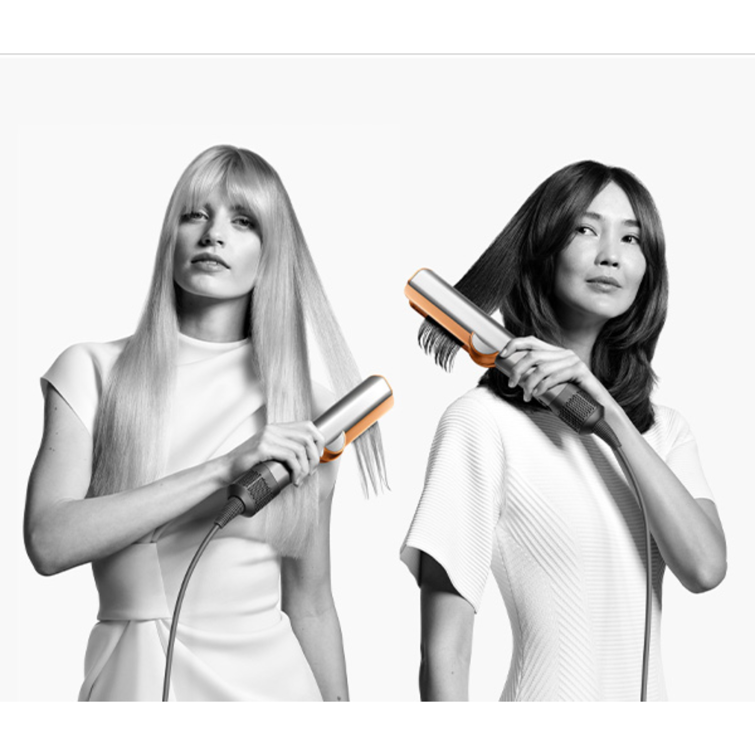 Two women flat ironing their hair, one with blonde hair, the other with dark hair.