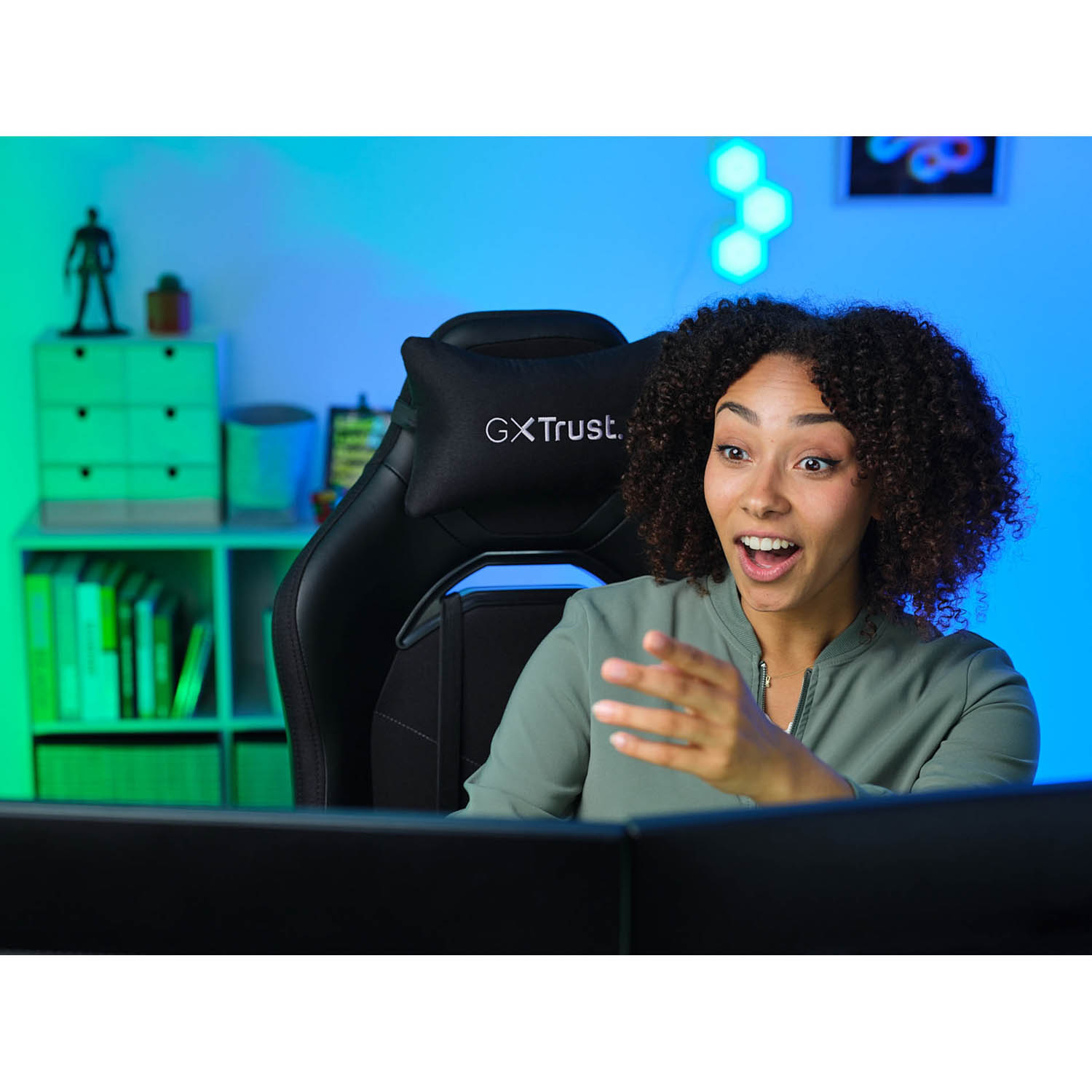 Donna su una sedia da gaming con espressione eccitata, che guarda uno schermo. Un'impostazione di gioco colorata sullo sfondo.