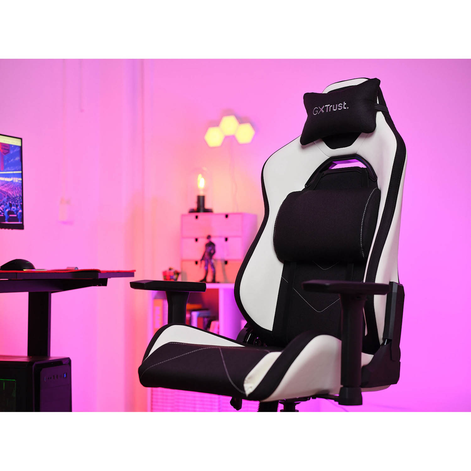 Una sedia da gioco con un design in bianco e nero, in una stanza con illuminazione rosa.
