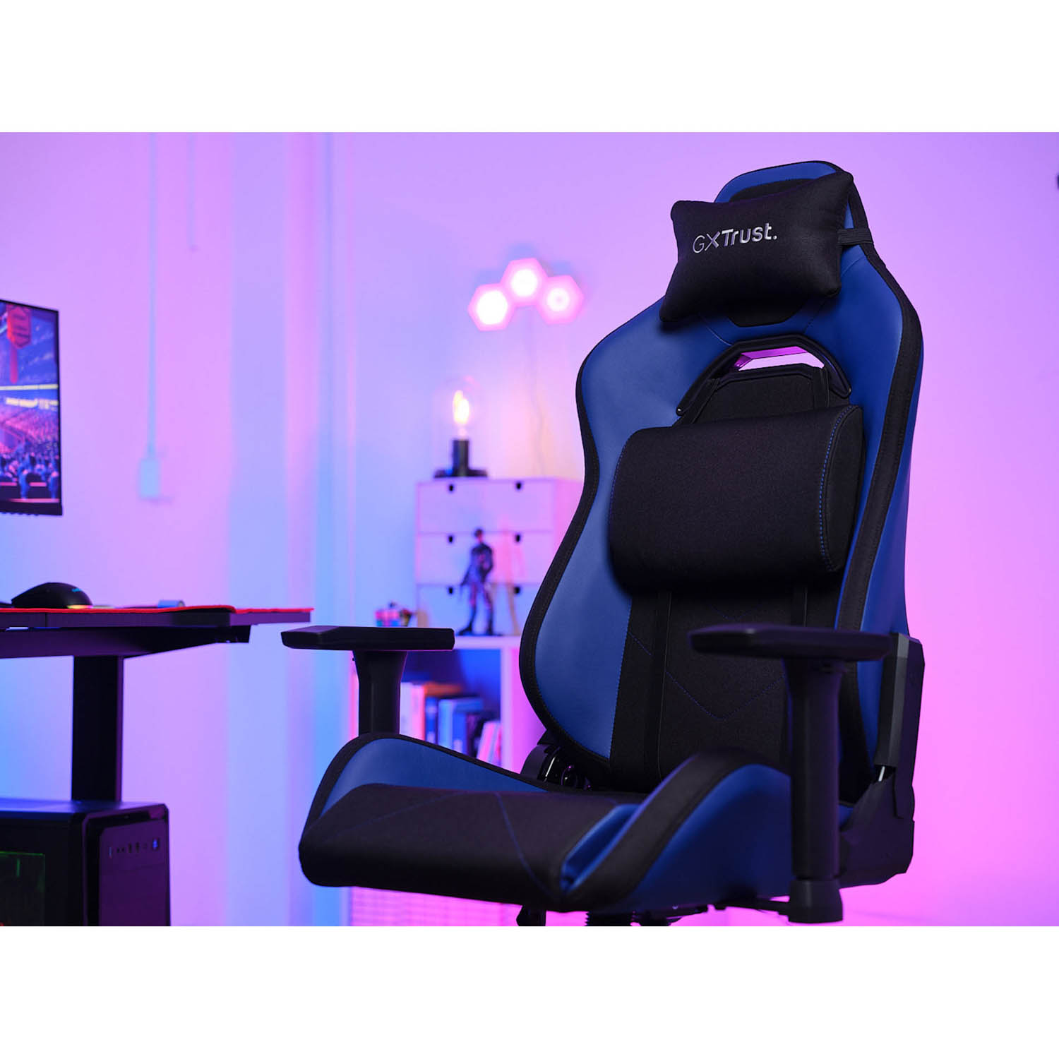 Sedia da gaming blu e nera, con poggiatesta e supporto lombare, in una sala giochi.