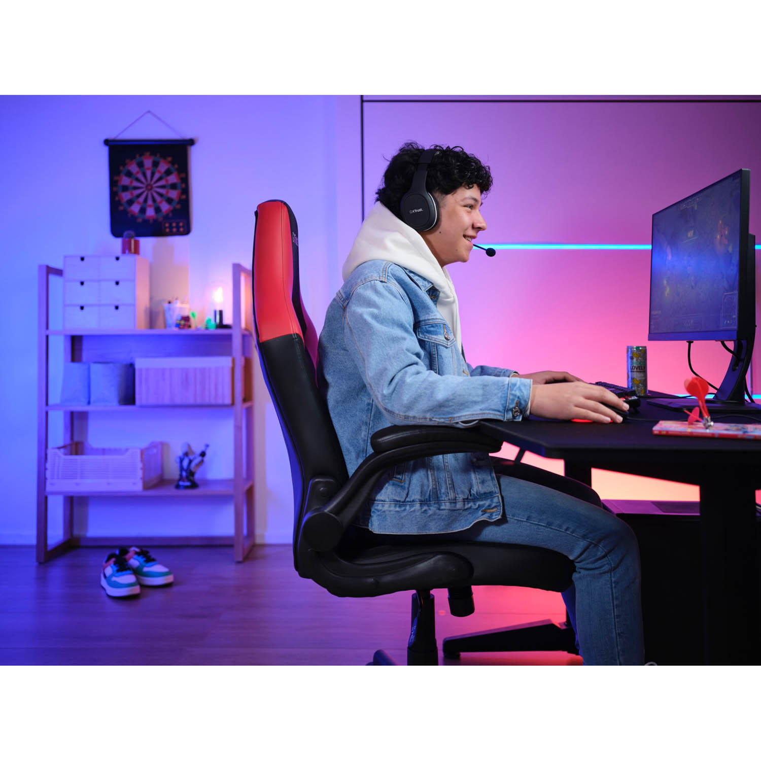 Un giocatore è in una sala giochi, indossa un'auricolare e gioca su un monitor.