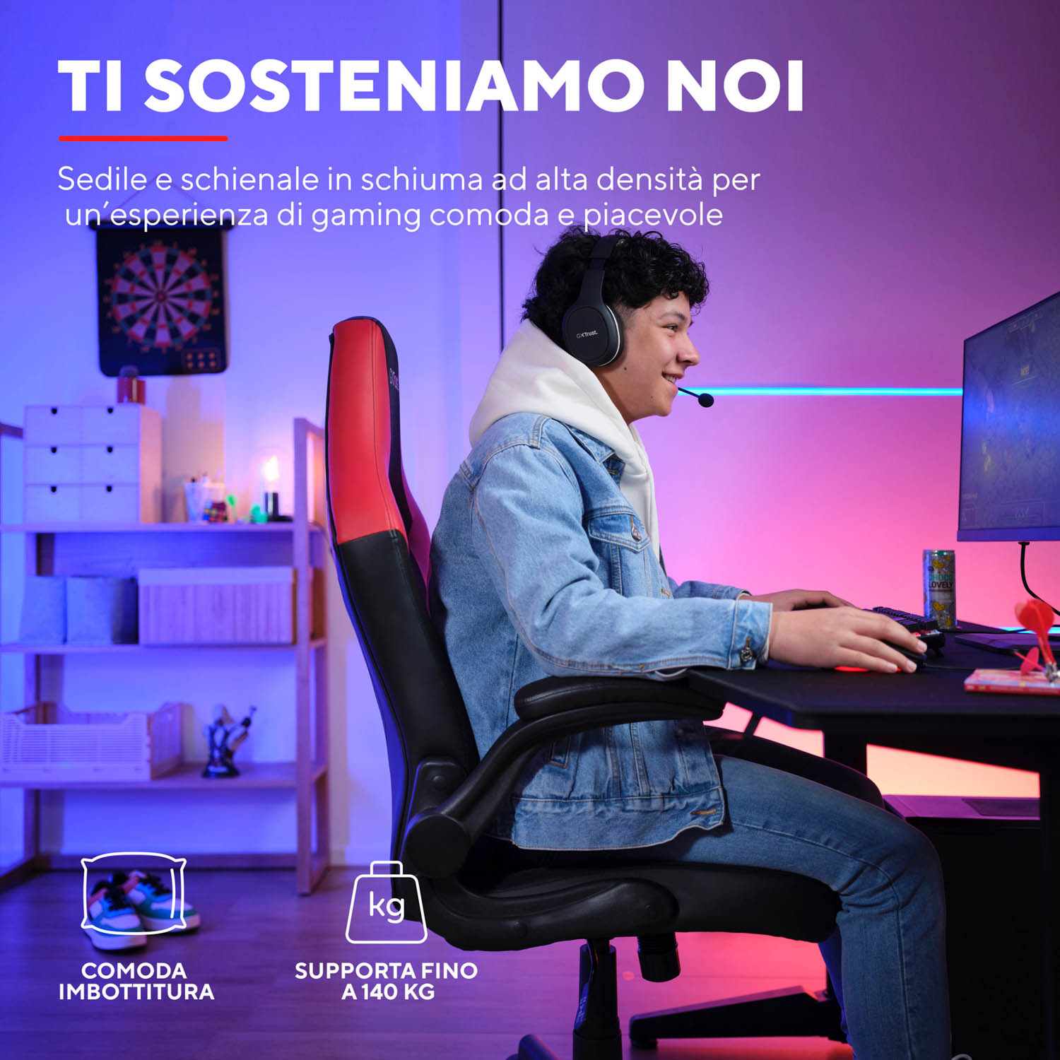 Un uomo usa un computer, seduto su una sedia da gaming. La sedia ha accenti rossi e neri. Cuffie indossate.