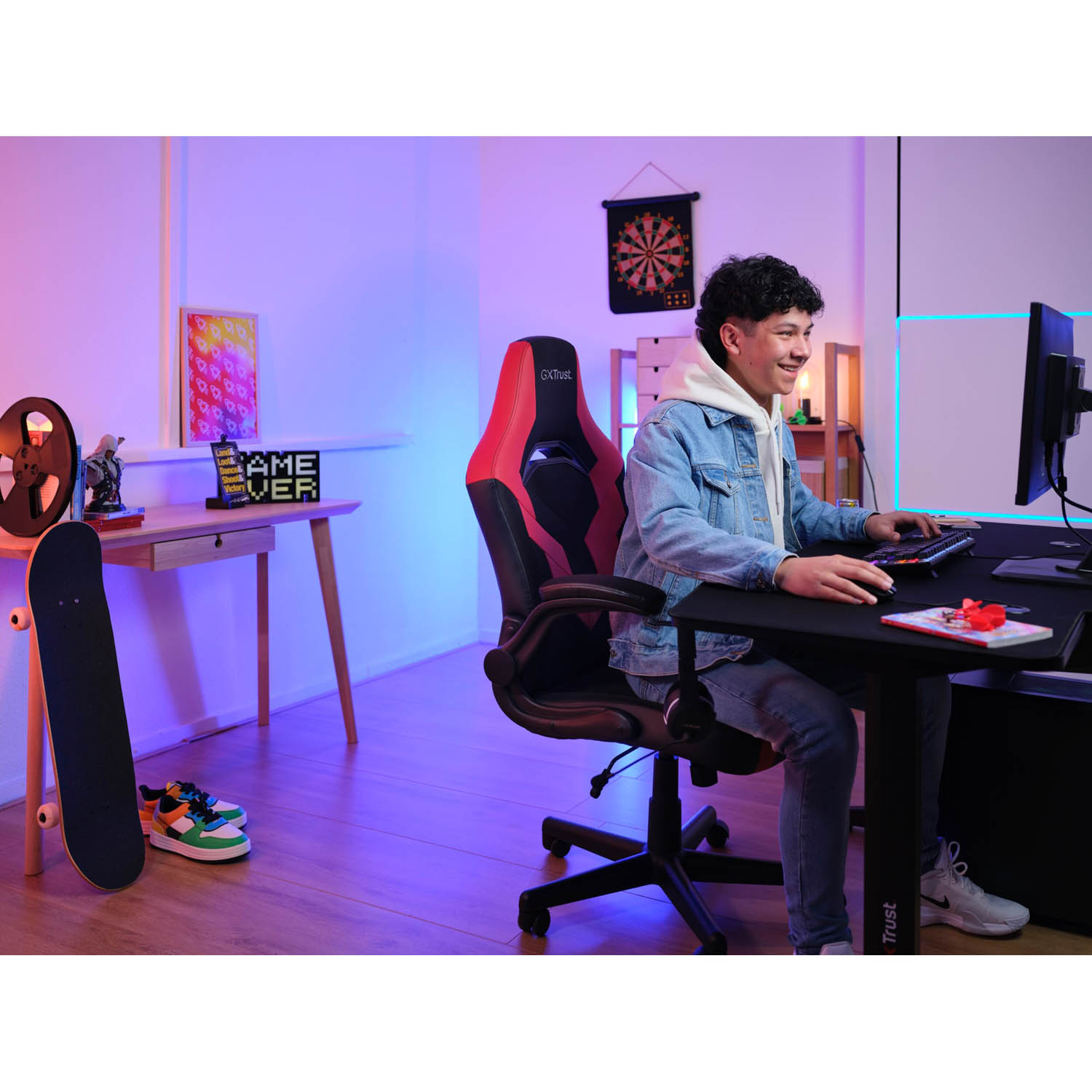 Un giovane a una scrivania, che gioca con un setup di computer.