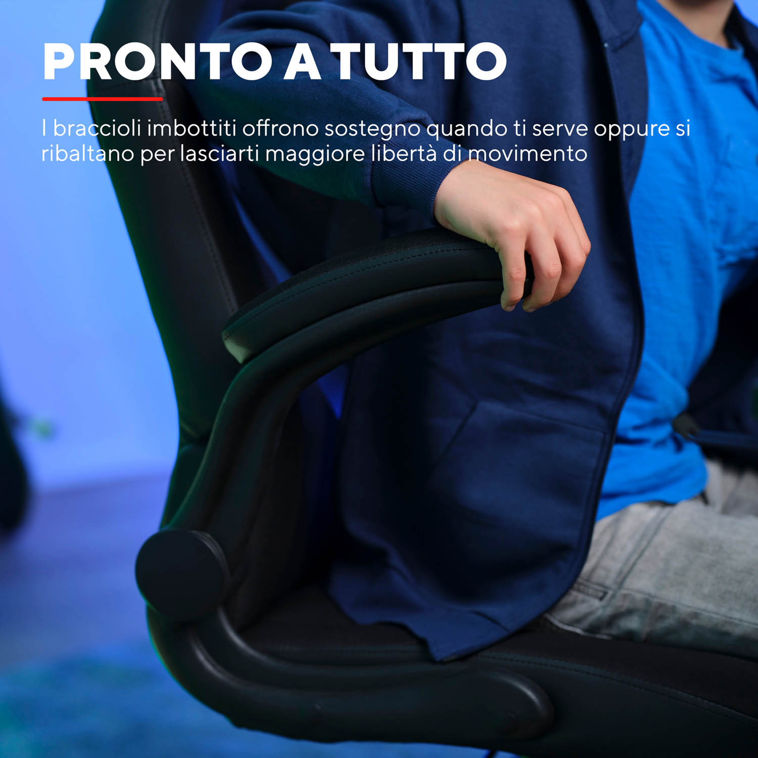 Il braccio di una persona poggia sul bracciolo di una sedia da gaming nera, testo: Pronti a tutto.