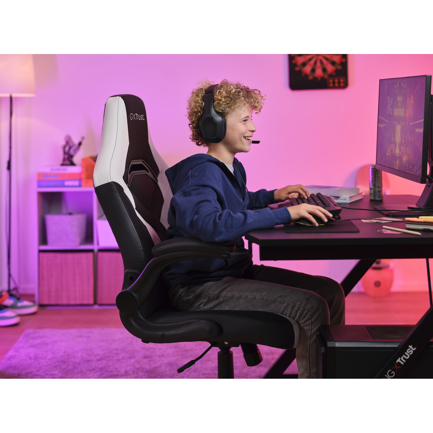 Ragazzo gamer seduto su una sedia da gioco che gioca al computer con cuffie e microfono.