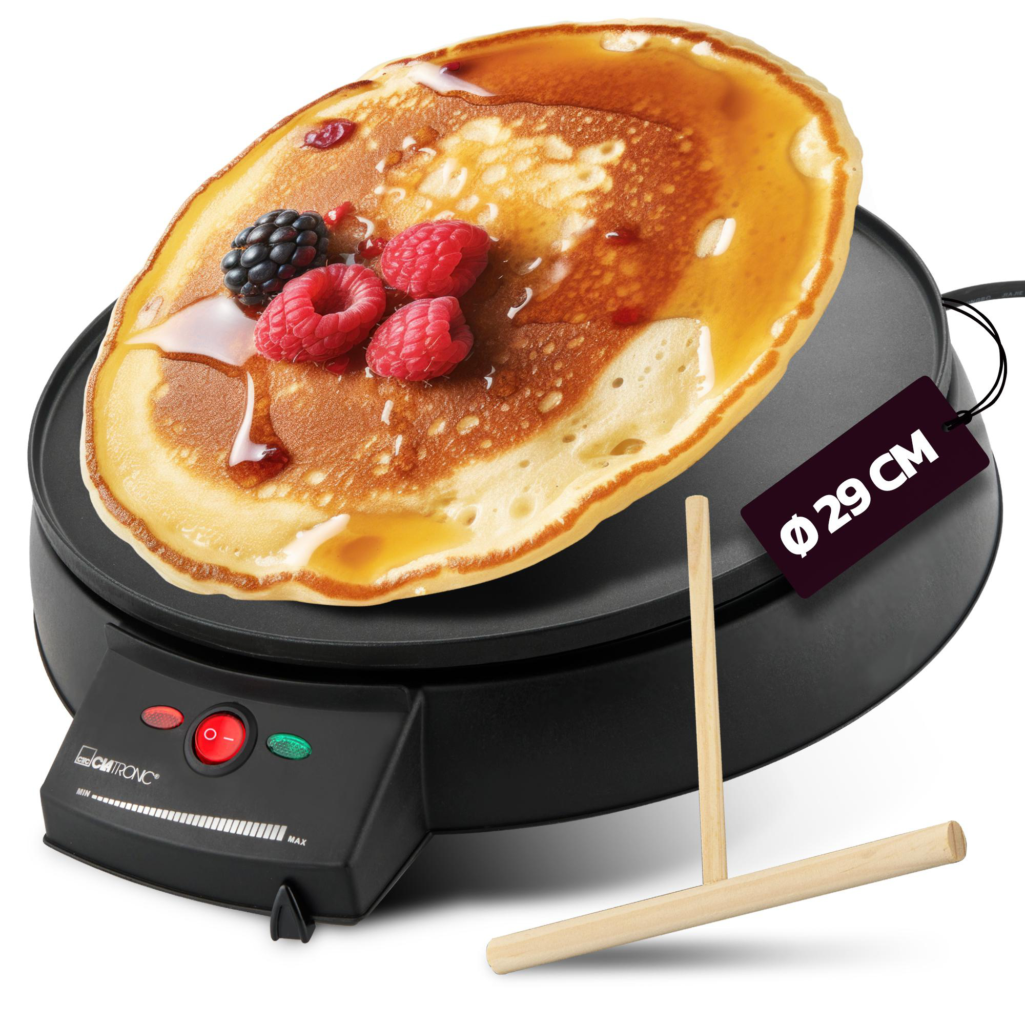 Pfannkuchen auf einer schwarzen Grillplatte mit Sirup und Beeren. Ein Holzstreuer und Anhänger vorhanden.