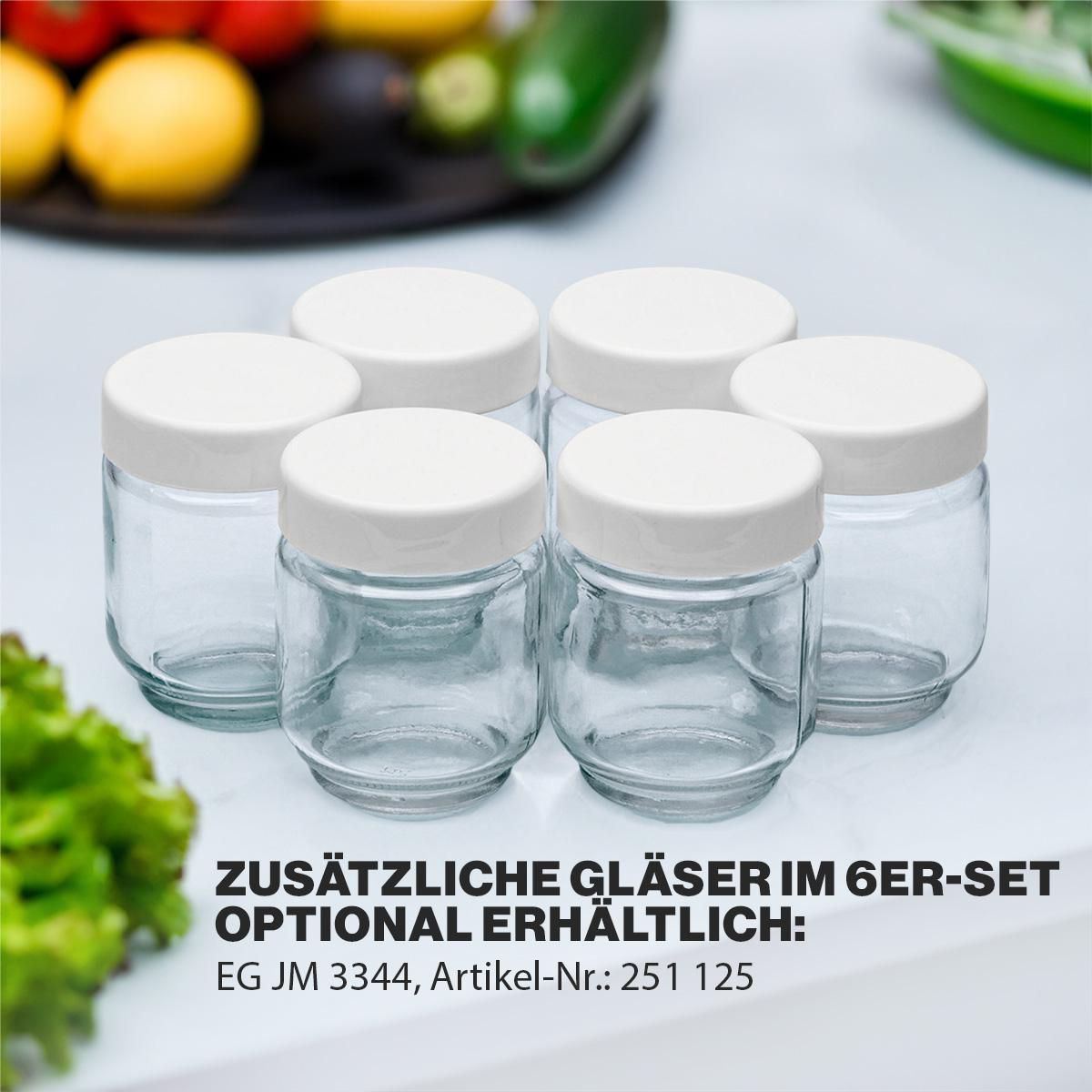 Sechs Gläser mit weißen Deckeln. Die Gläser stehen auf einer weißen Oberfläche. Grüne Blätter in der Ecke.