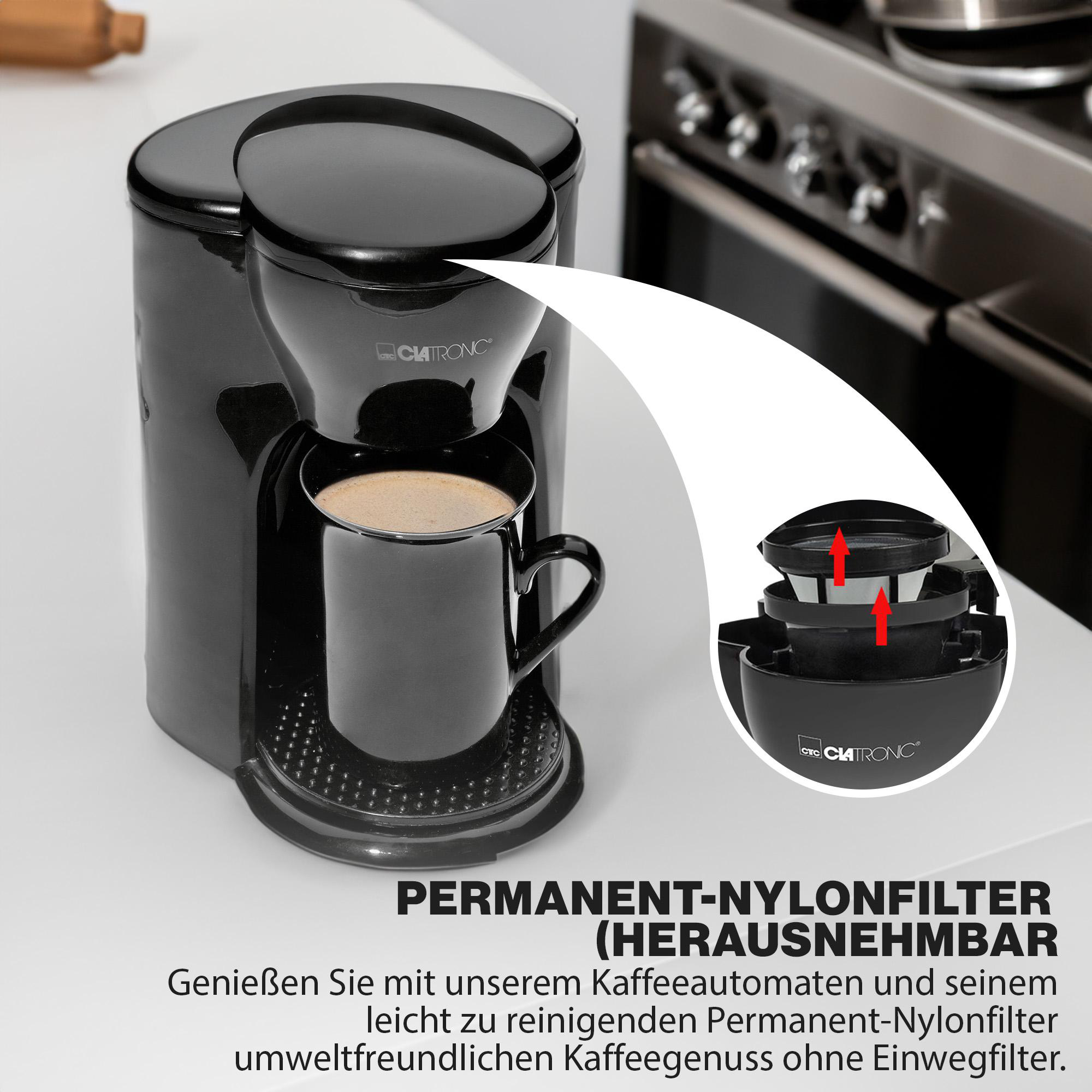Schwarze Kaffeemaschine mit schwarzem Becher. Detail zeigt Filter und Kaffeetasse innen.