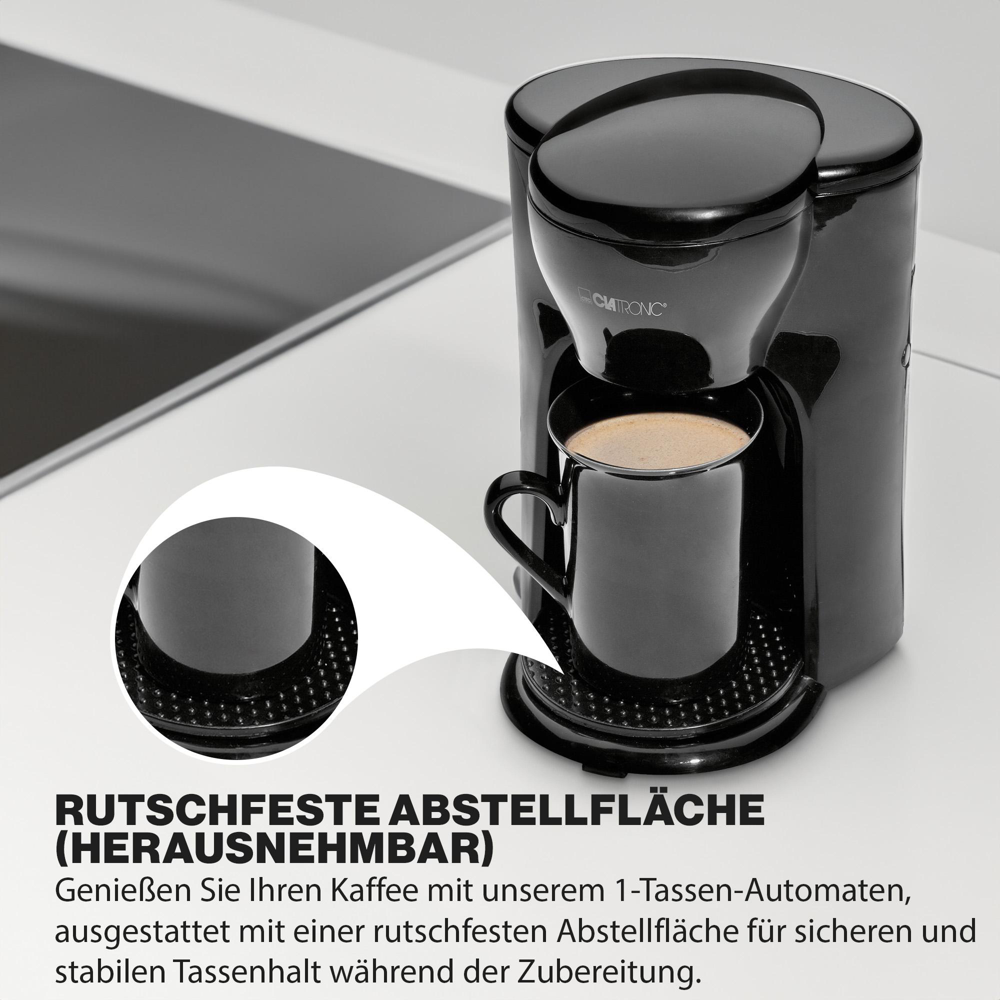 Schwarze Kaffeemaschine mit schwarzer Tasse, Detail der rutschfesten Oberfläche. Text: Rutschfeste Oberfläche.