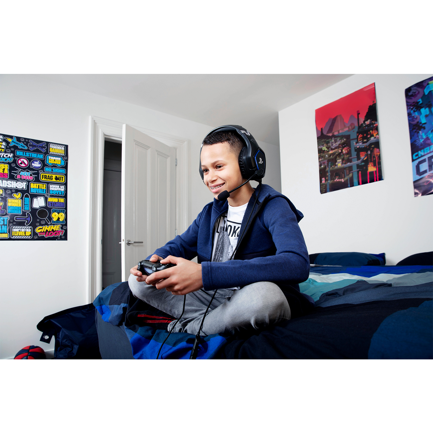 Ragazzo che gioca ai videogiochi a letto, indossa le cuffie e tiene un controller.