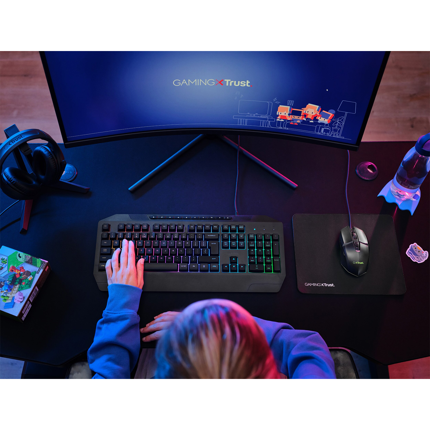 Vista dall'alto di una configurazione di gioco: tastiera, mouse, monitor e una bevanda sulla scrivania.