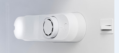 Appareil blanc avec un cadran et un bouton. Situé à l'intérieur d'un espace blanc.