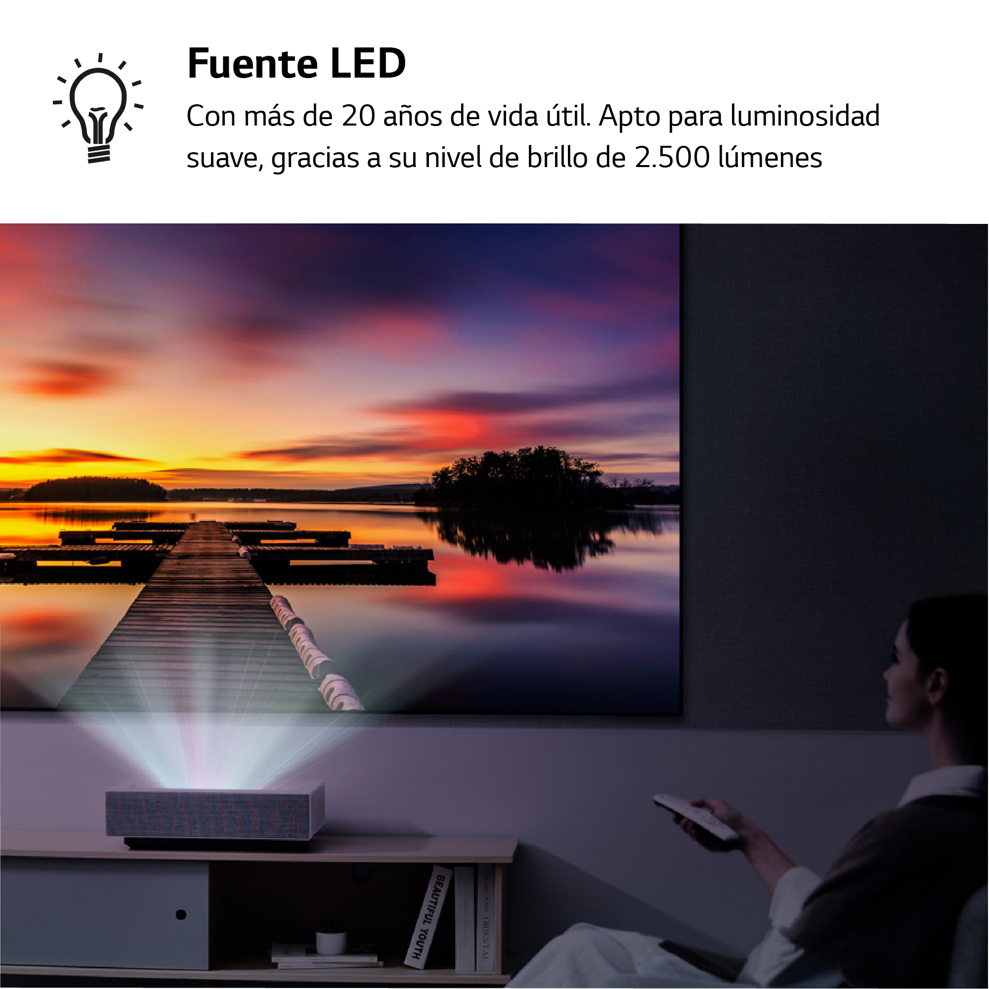 Un proyector que muestra una escena de puesta de sol en una pantalla grande, con texto y un mando a distancia.