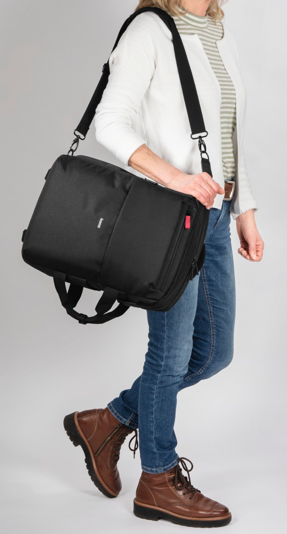 Une femme portant un sac noir avec une bandoulière.