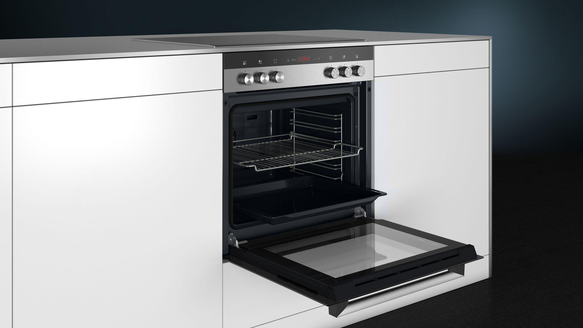 Ein Backofen mit geöffneter Tür, der Roste und ein Backblech zeigt. Der Ofen ist in einen weißen Schrank eingebaut.