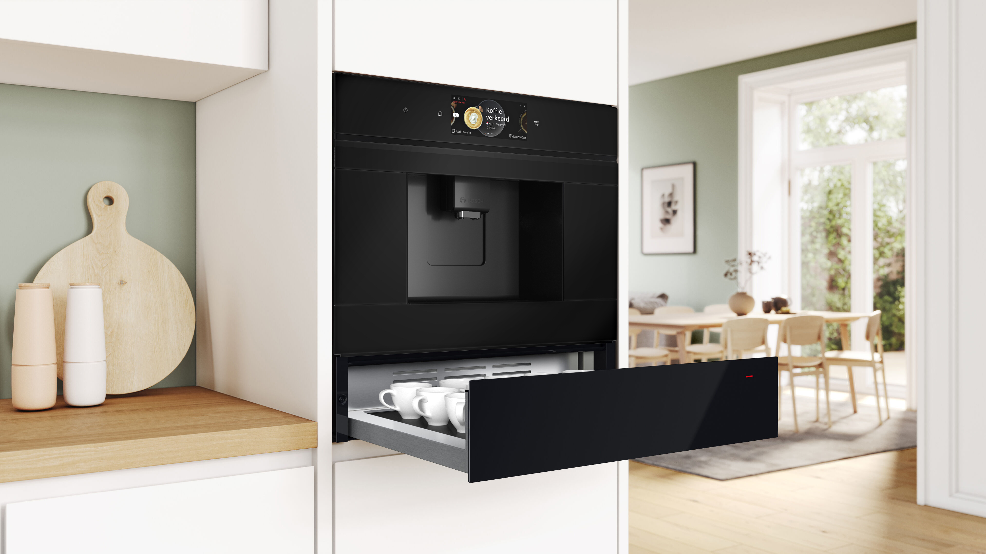 Eingebaute schwarze Kaffeemaschine und eine Schublade mit Tassen in einer Küche.