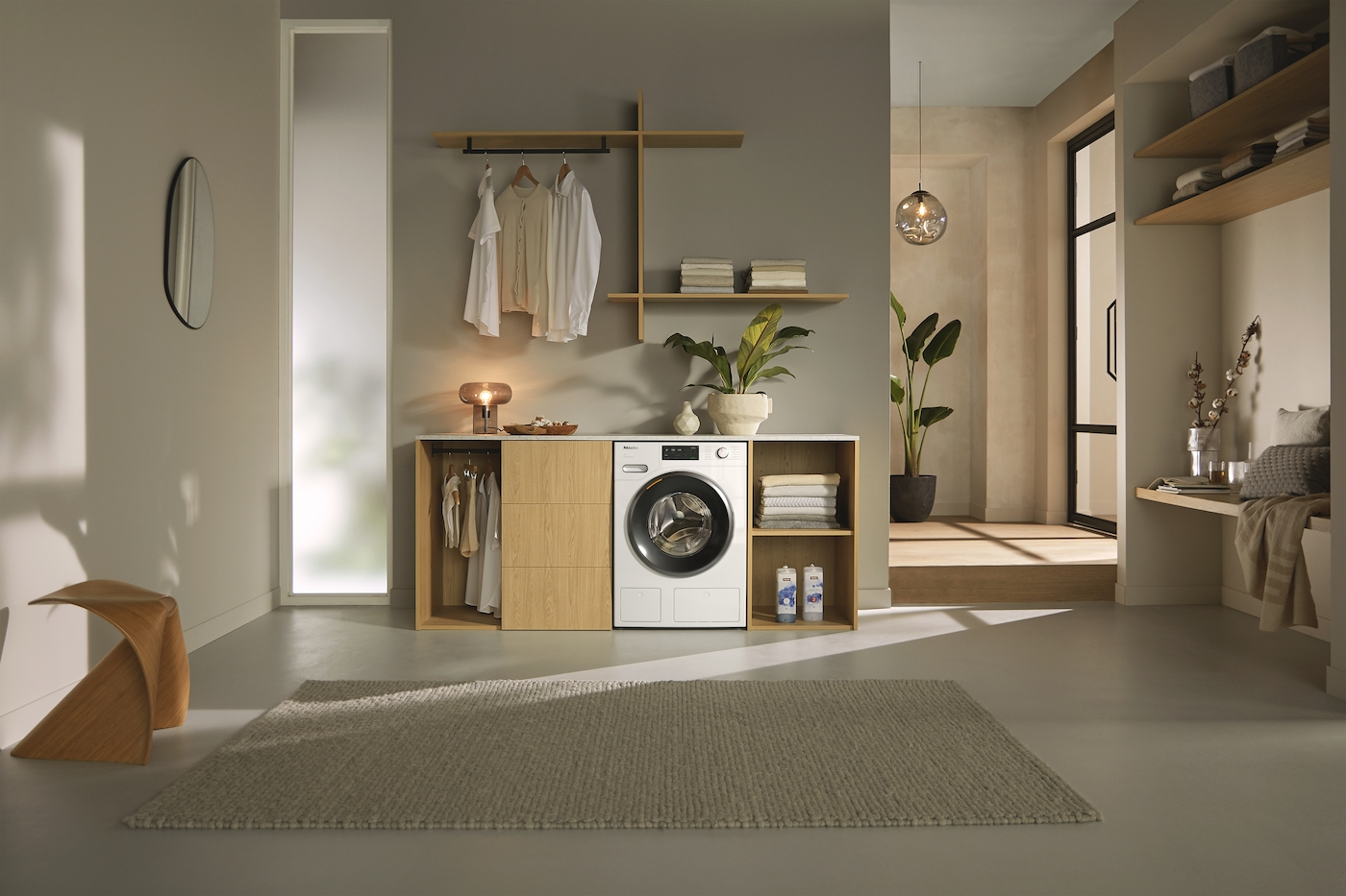 Ein moderner Waschraum mit Waschmaschine, Holzschränken und einem Teppich.