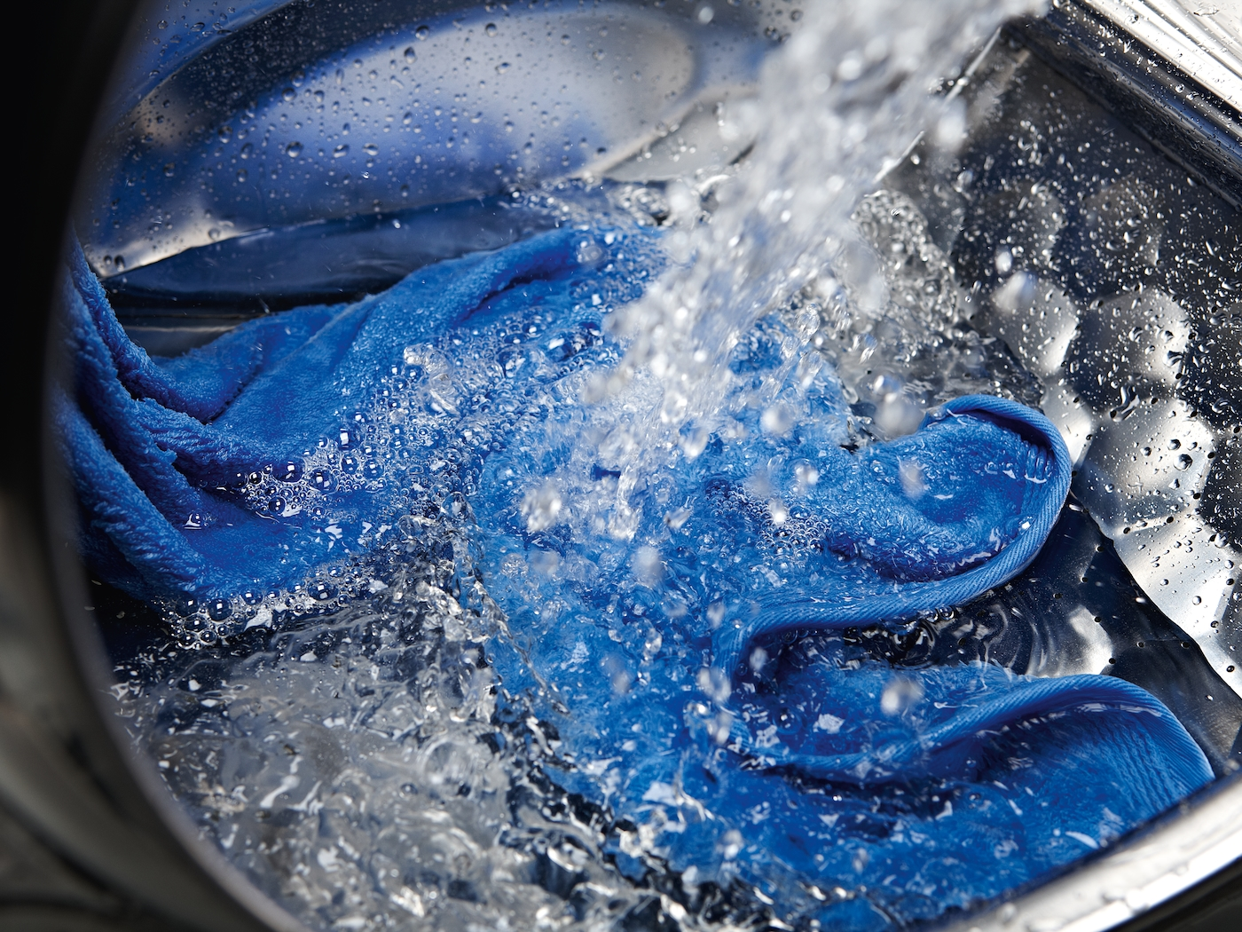 Blaues Tuch wird in einer Waschmaschine gewaschen.