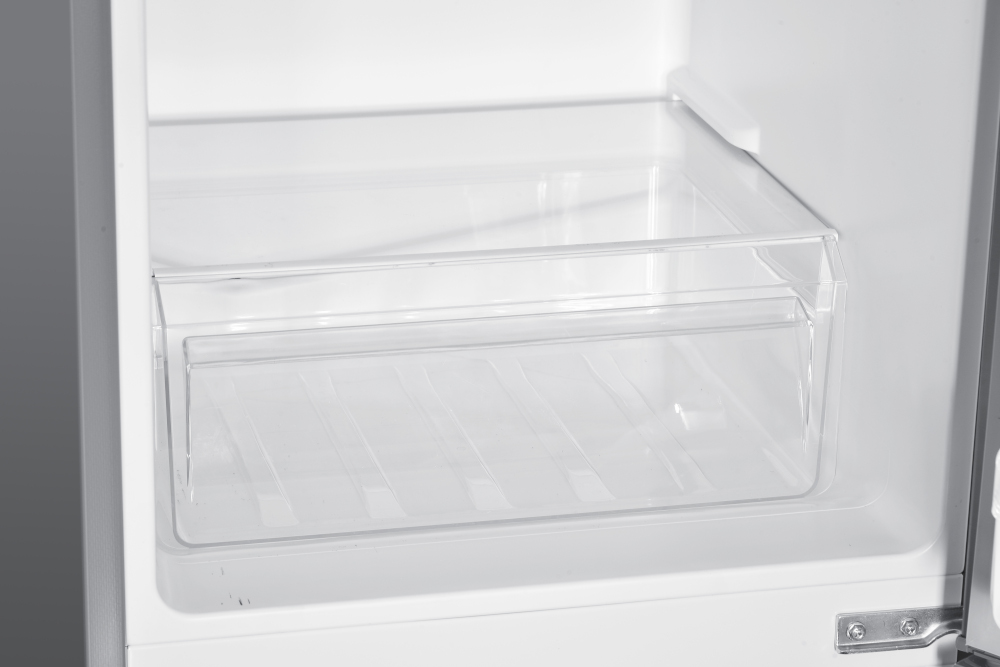 Tiroir en plastique transparent à l'intérieur d'un réfrigérateur. Il a une conception à deux niveaux.