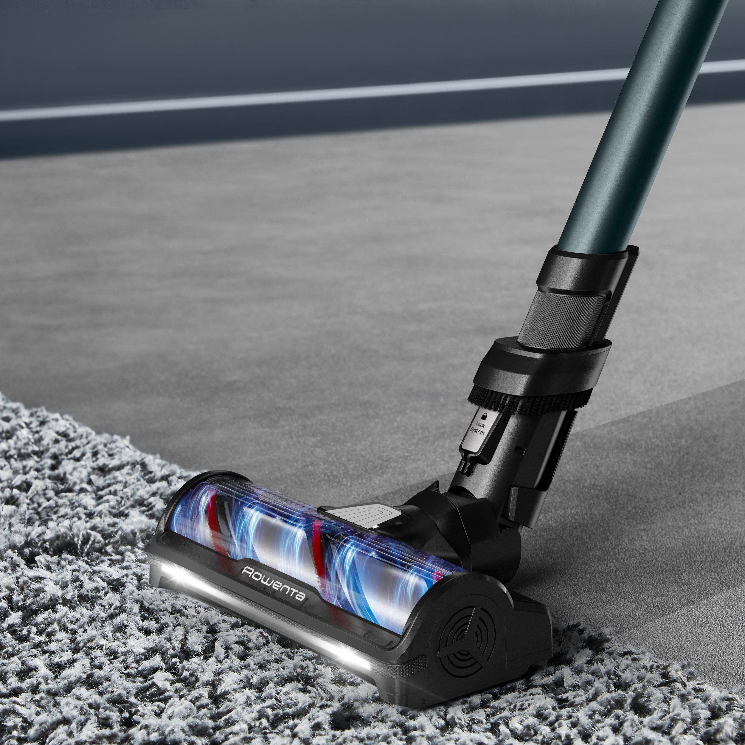 Ein schwarz-grauer Staubsaugerkopf, der einen grauen Teppich reinigt.