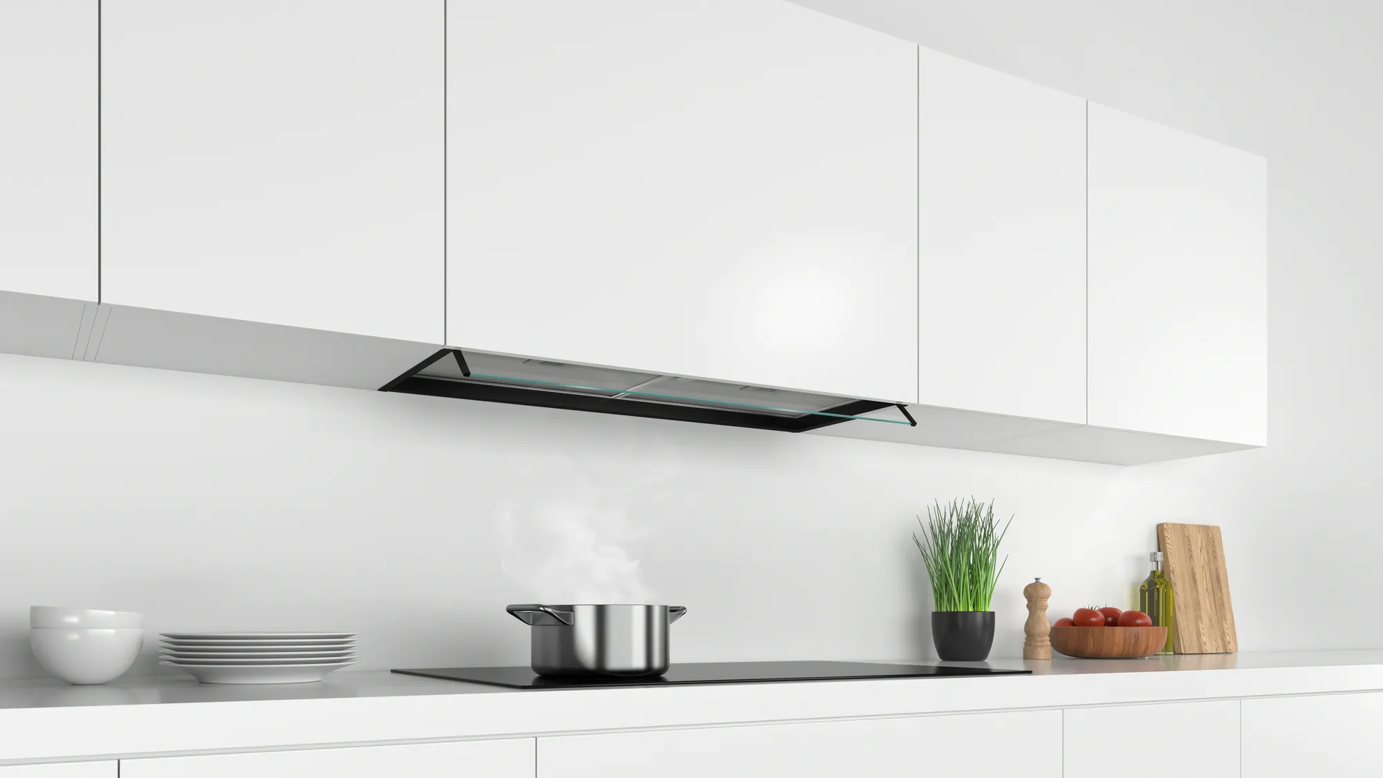 Une hotte aspirante noire au-dessus d'une table de cuisson à induction noire avec une casserole.